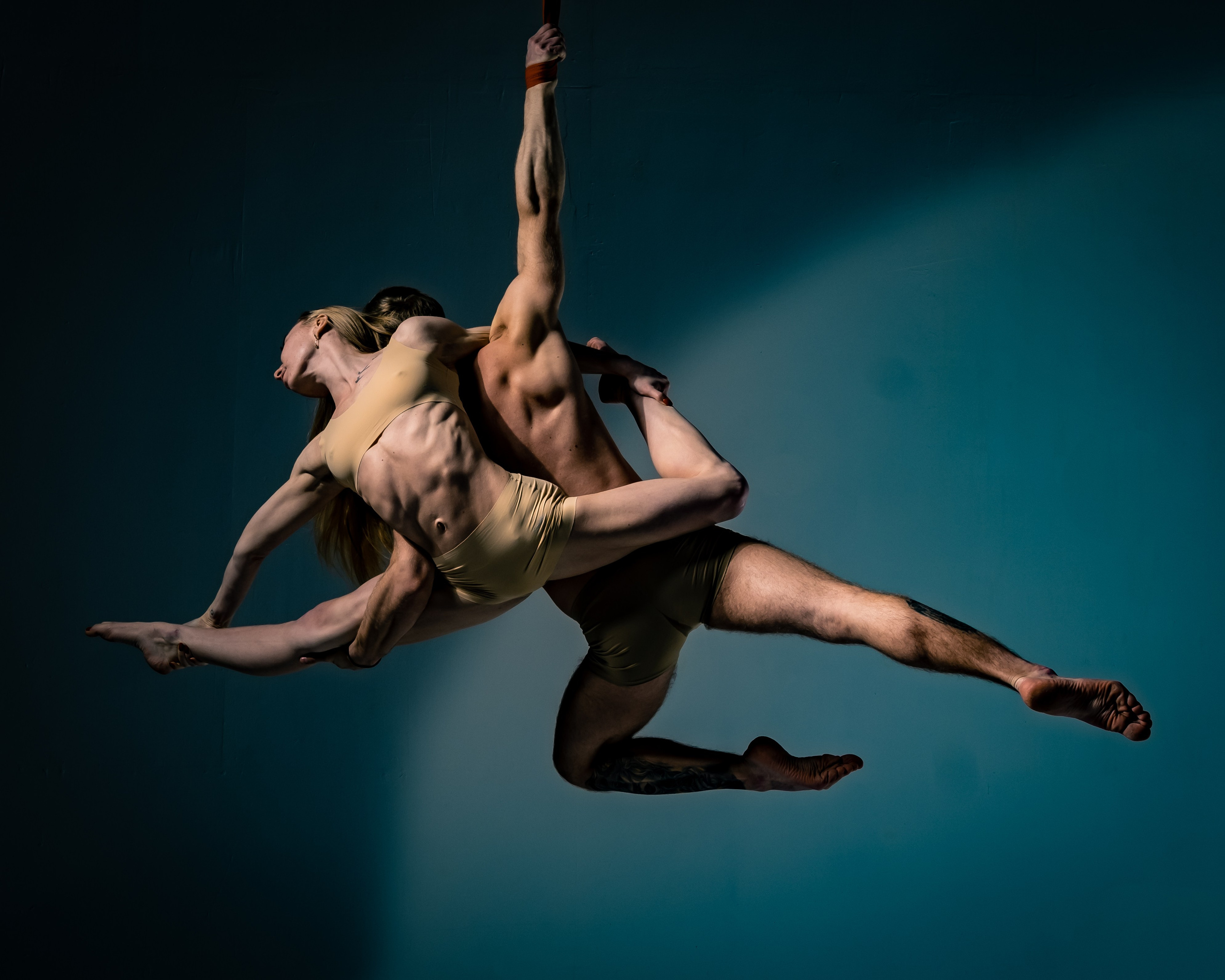 Творческий парный портрет воздушных гимнастов в акробатическом движении | Профессиональная студийная фотосессия для танцоров, гимнастов, артистов цирка и спортивного портфолио с акцентом на движение, тело и пластику