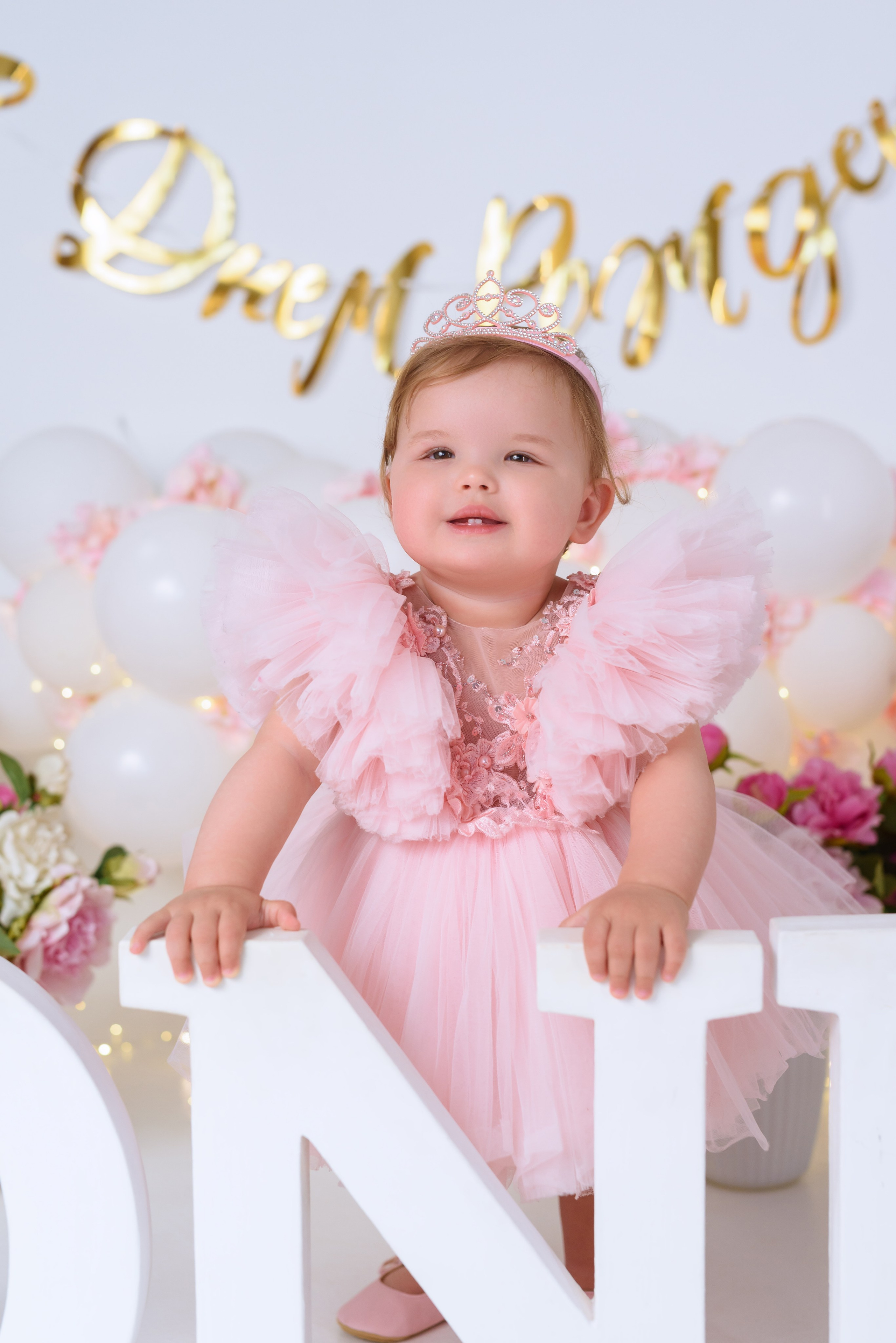 Маленький ребёнок улыбается во время фотосессии в студии