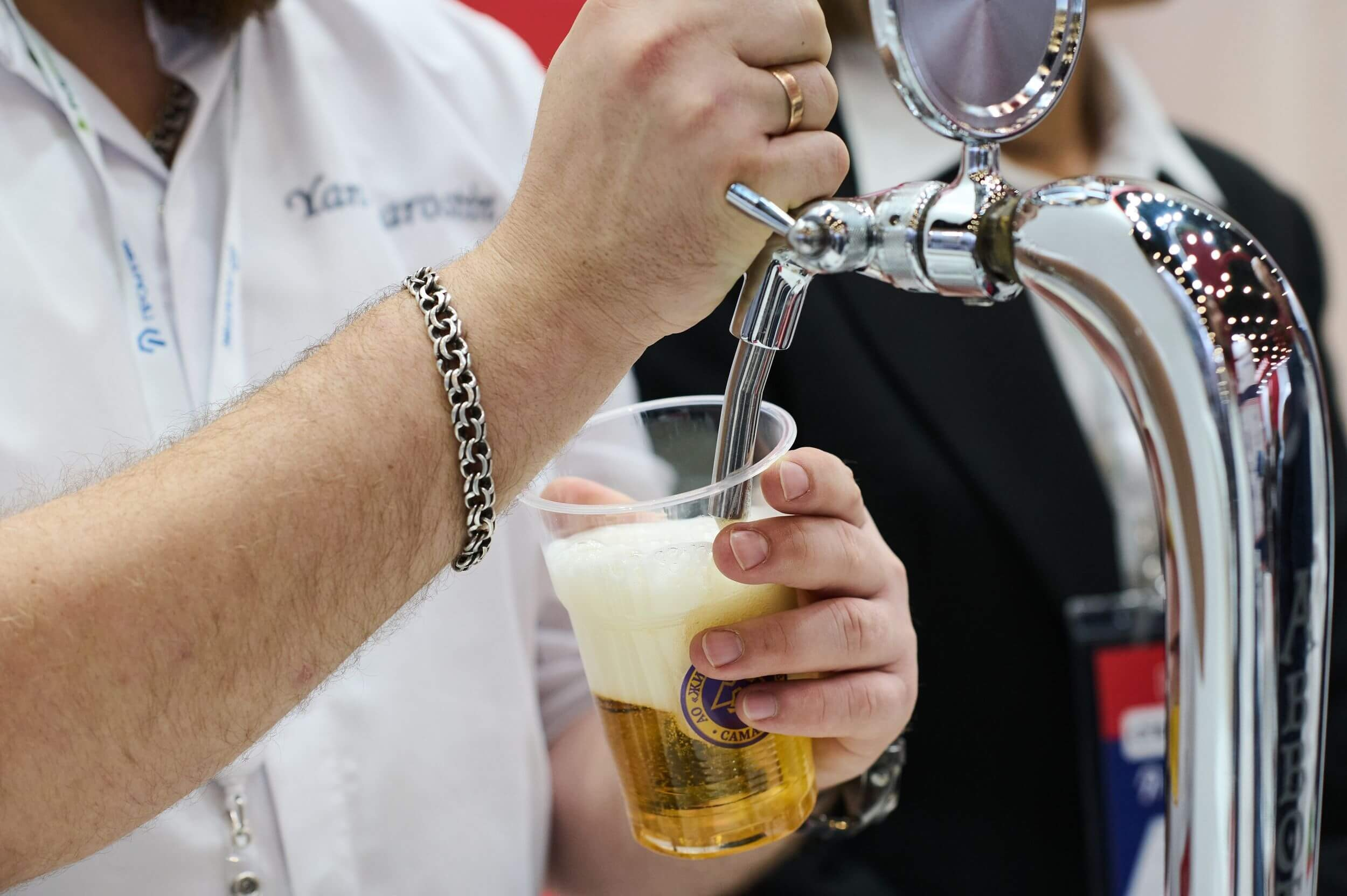 39. Мужчина наливает пиво на выставке.