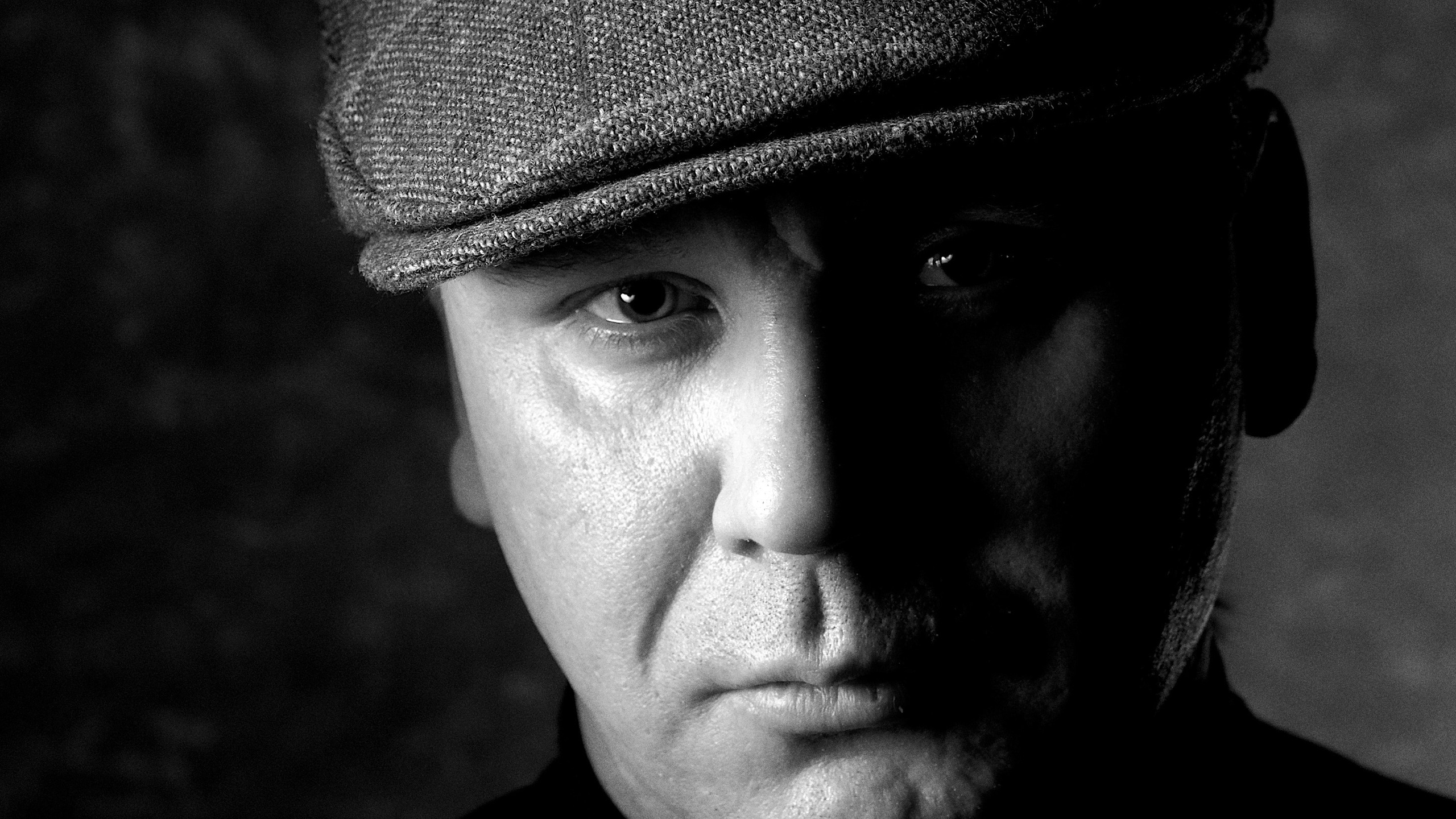 Эмоциональный черно-белый мужской портрет: харизматичный мужчина в кепке, драматичная художественная фотосессия, фотограф для актеров и музыкантов, портфолио для творческих личностей.