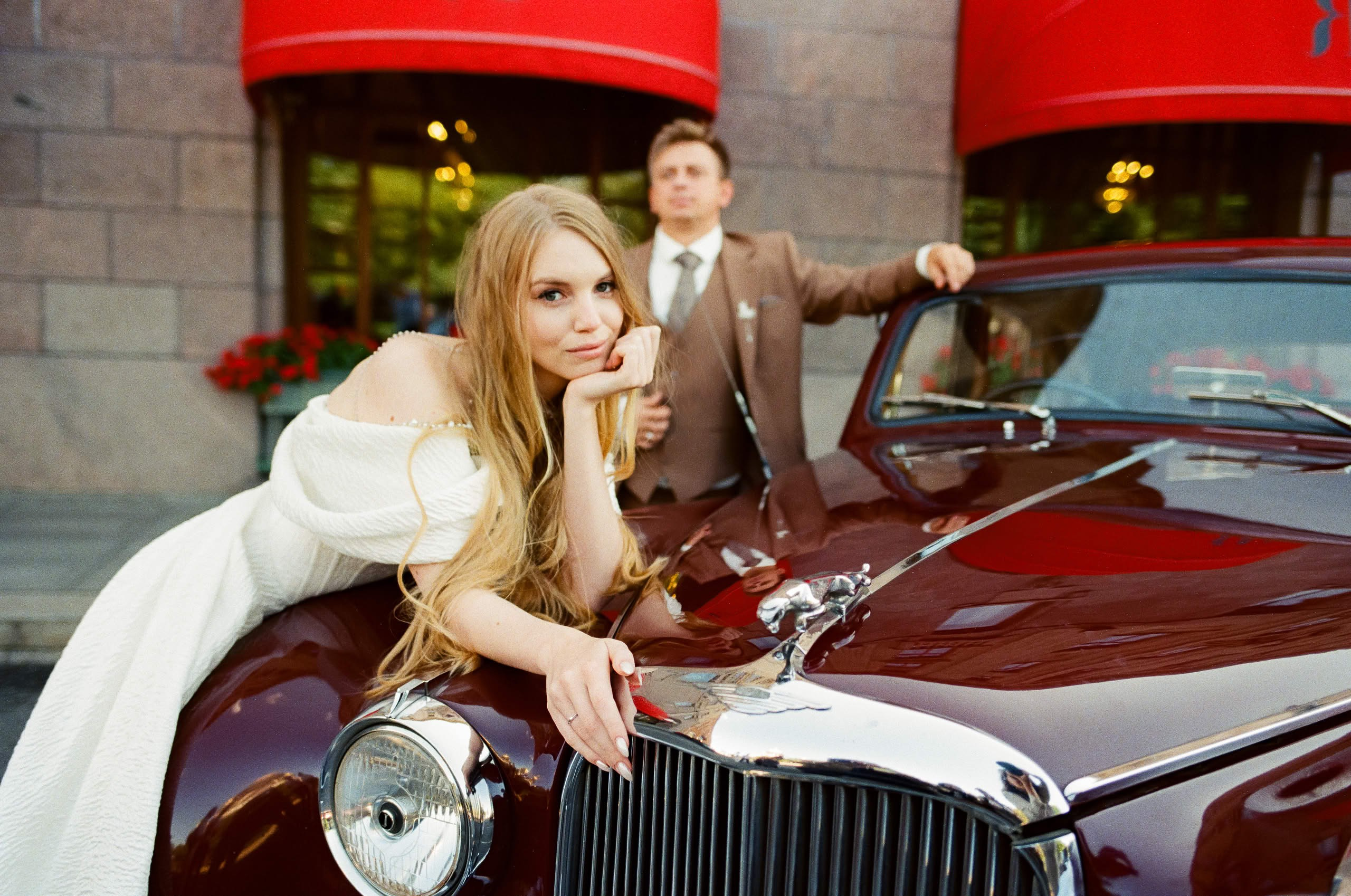 Жених и невеста рядом с винтажным Jaguar во время свадебной фотосессии в Санкт-Петербурге.