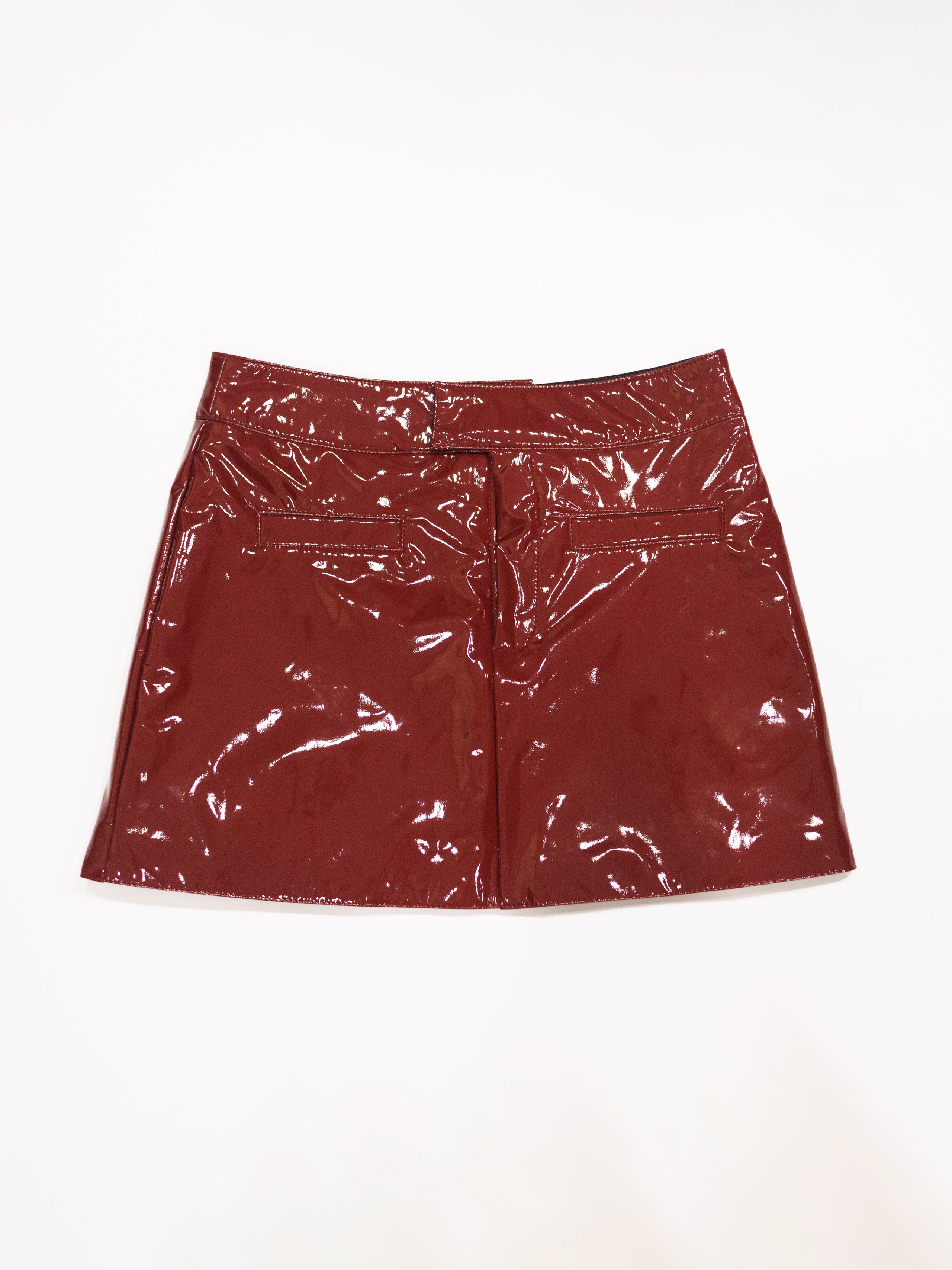 Съемка бордовой кожаной юбки на белом фоне