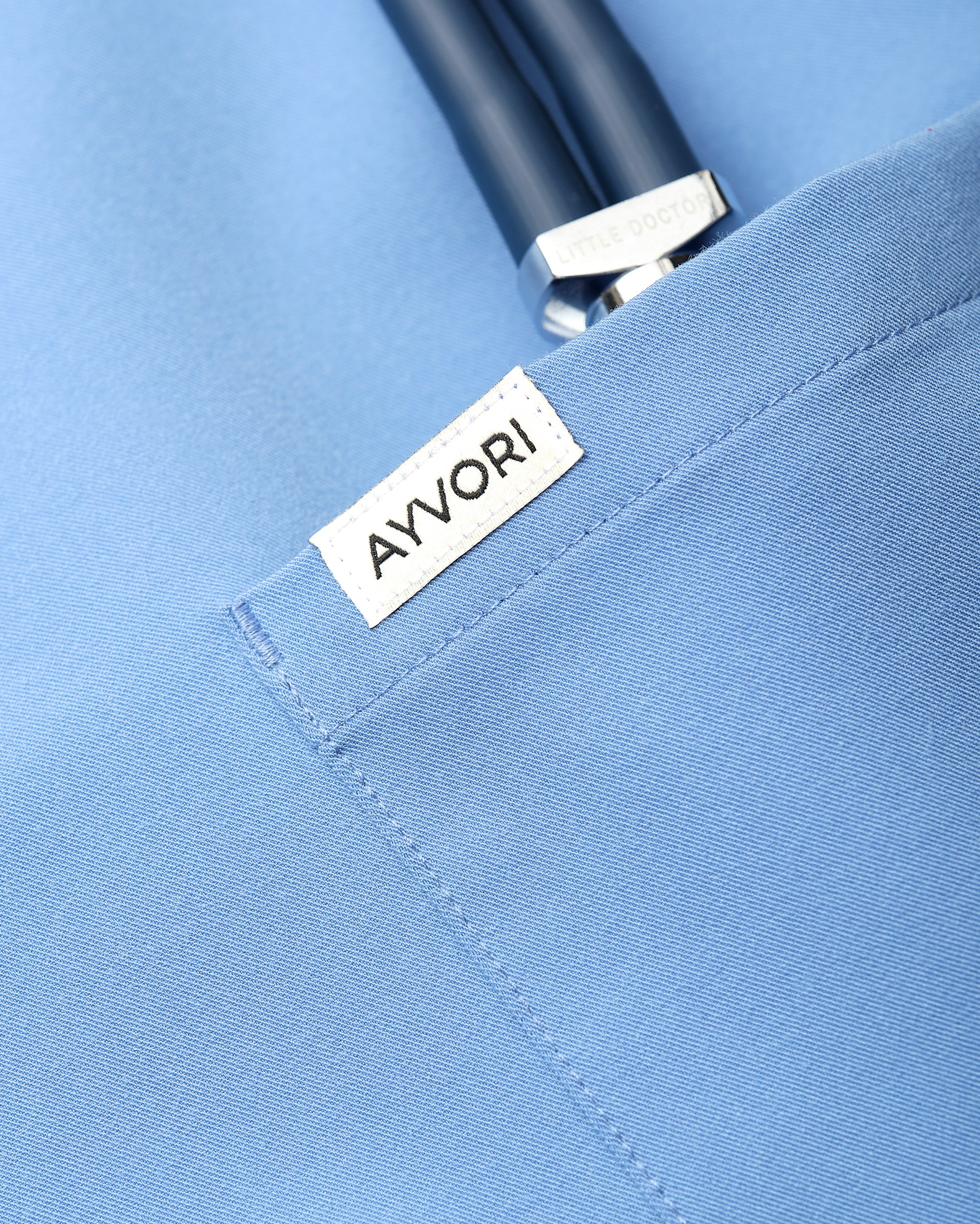 Крупный план кармана с логотипом AYVORI — предметная фотосъёмка медицинской одежды для передачи деталей