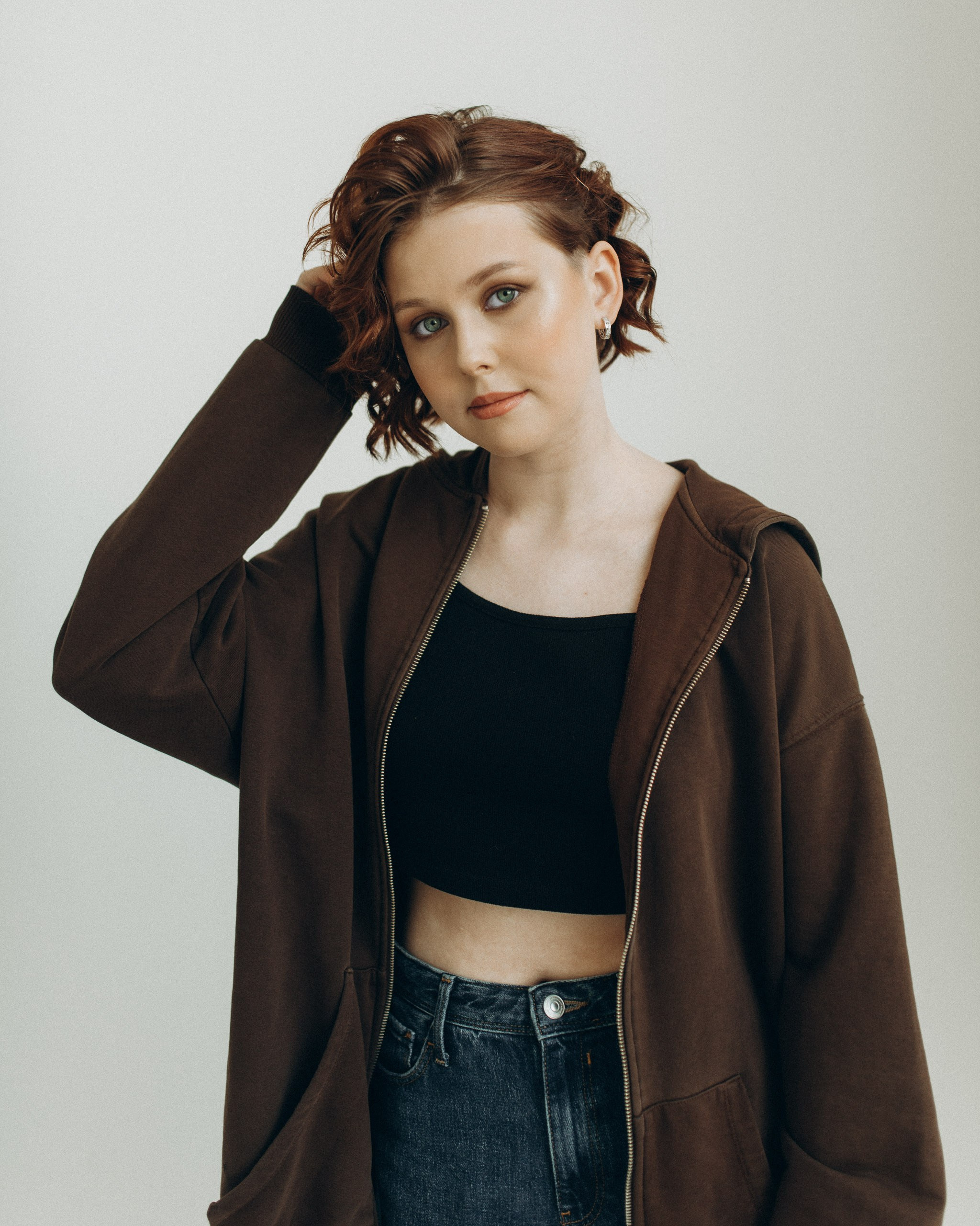 Естественный портрет девушки с зелеными глазами. Крупный план, рука в рыжих волосах. Первая профессиональная фотосессия в 15 лет