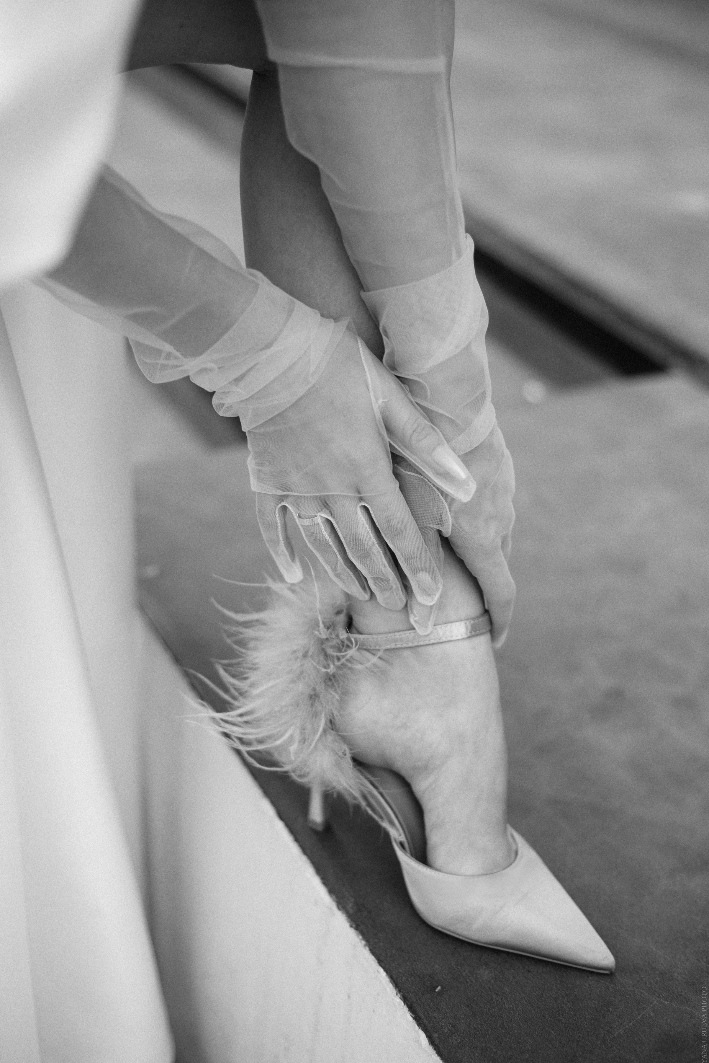 Невеста поправляет туфлю рукой в прозрачной перчатке