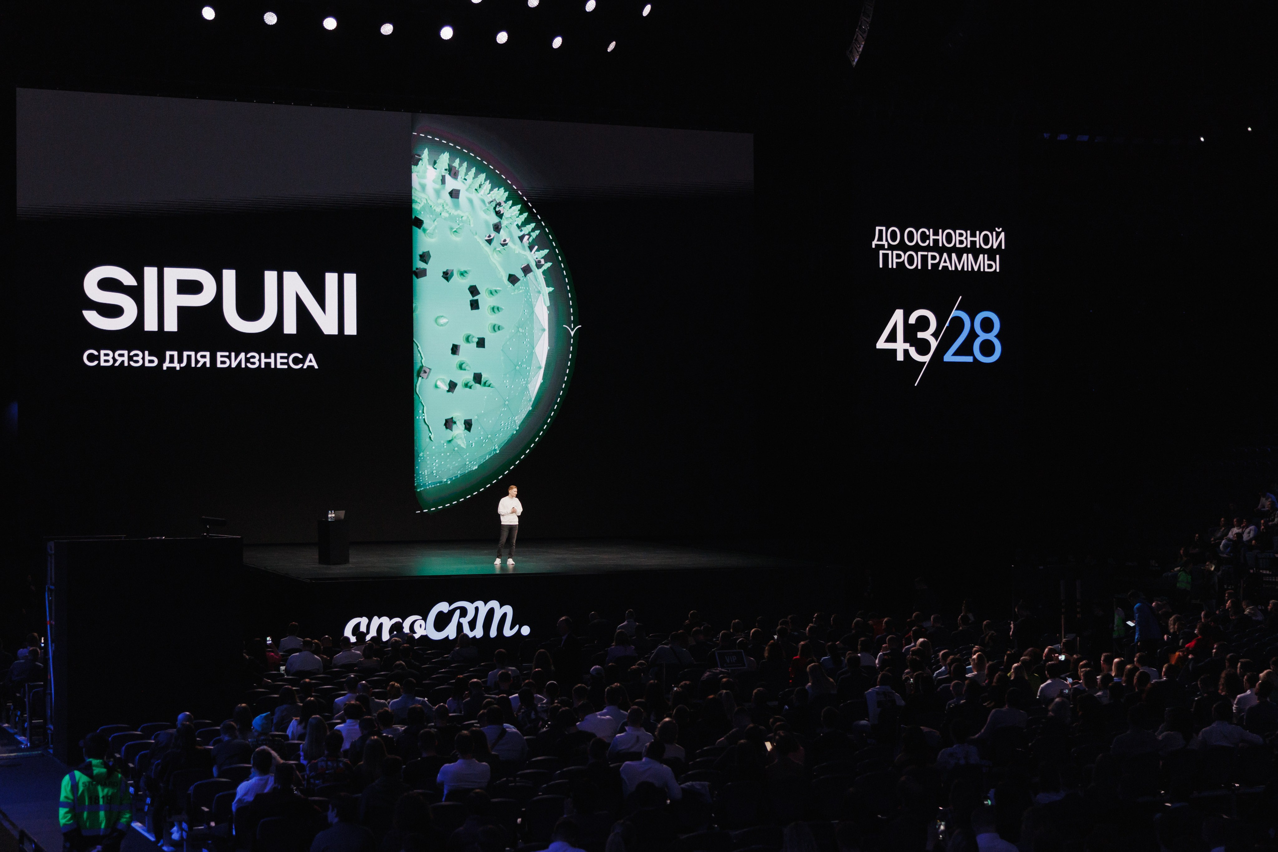 Взгляд из глубины зала: крупный план спикера на сцене во время презентации.