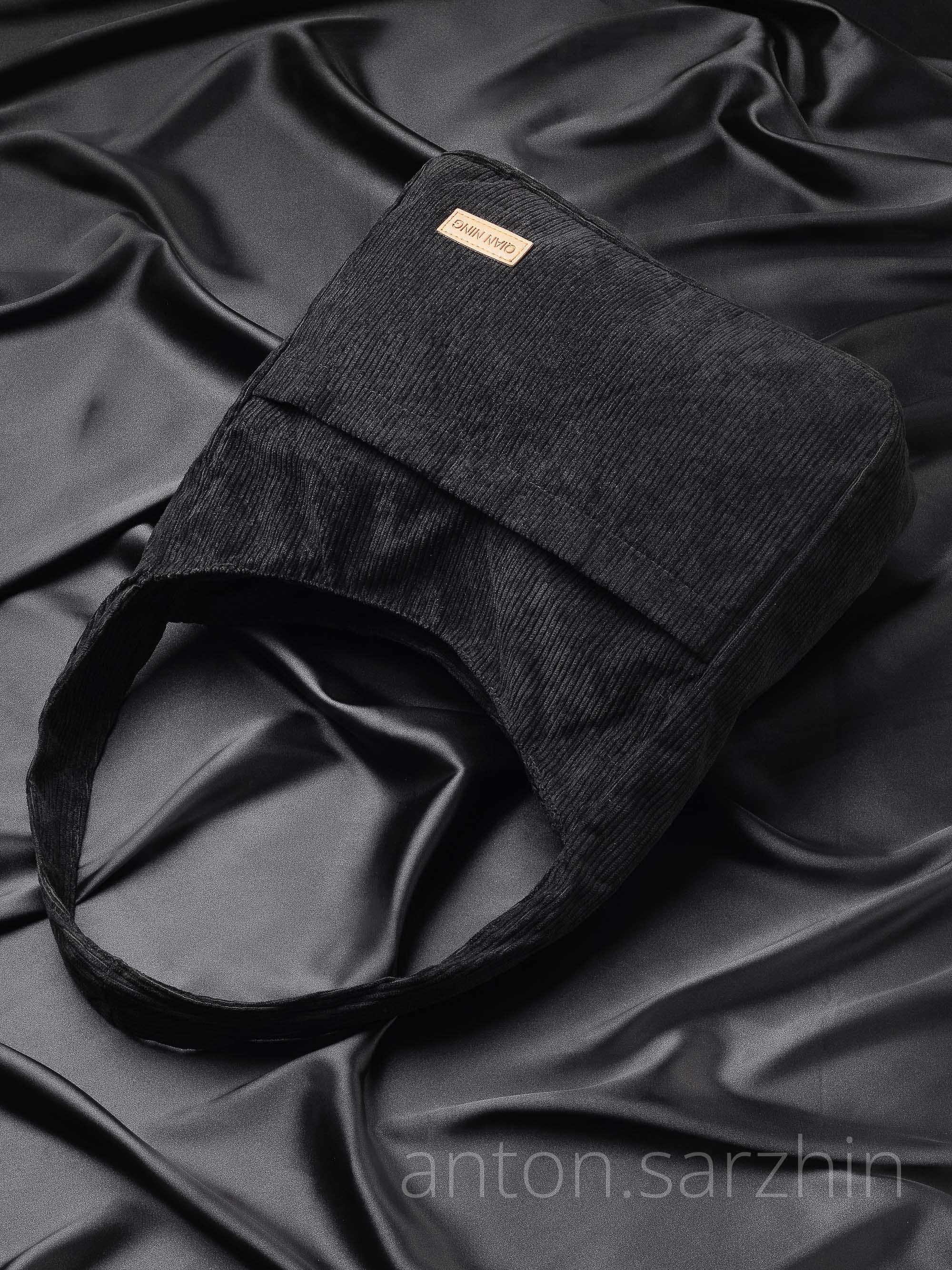 Предметная съемка женской сумки на черном шелке