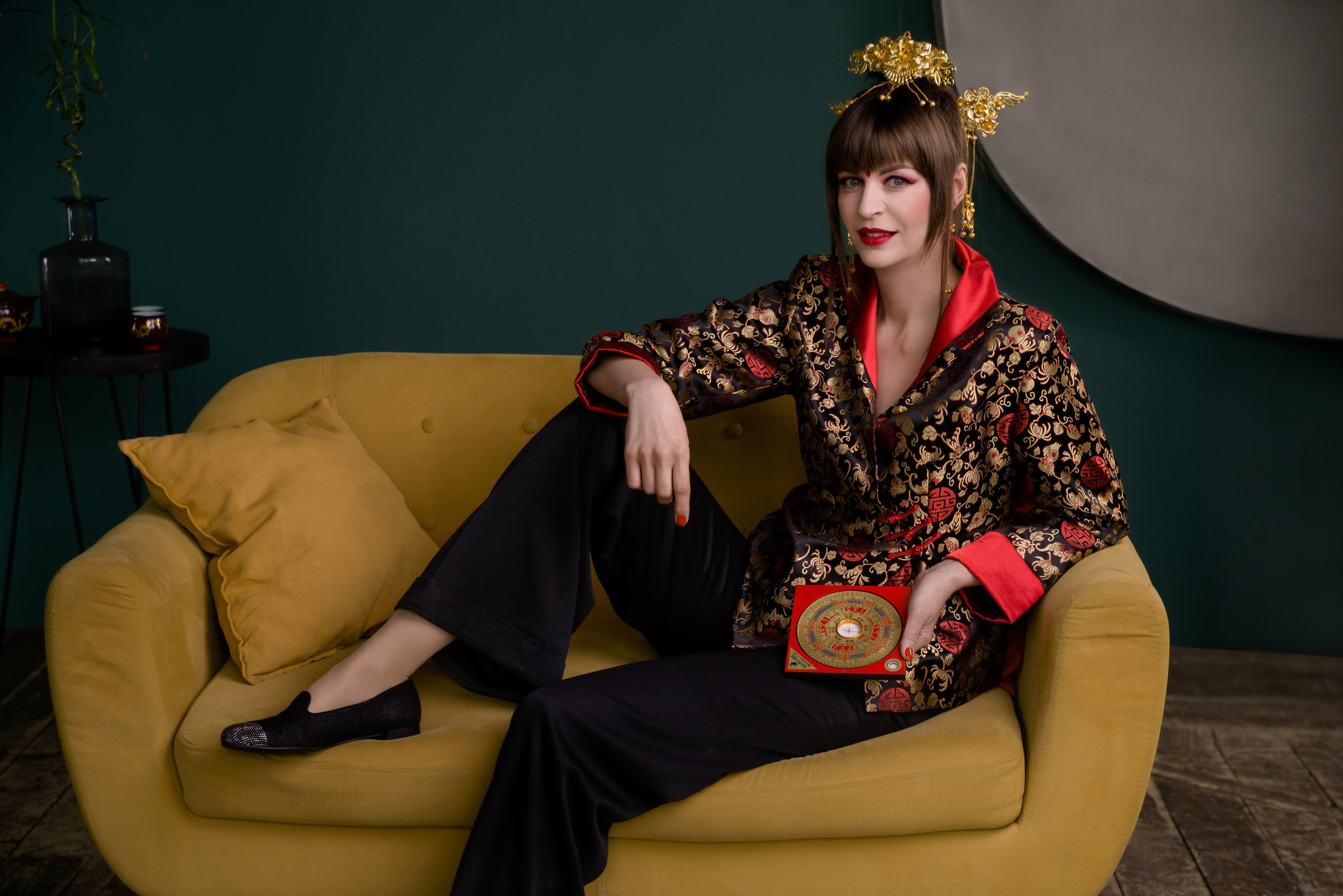 Девушка позирует в китайской красном костюме на желтом диване, астролог, ба цзы