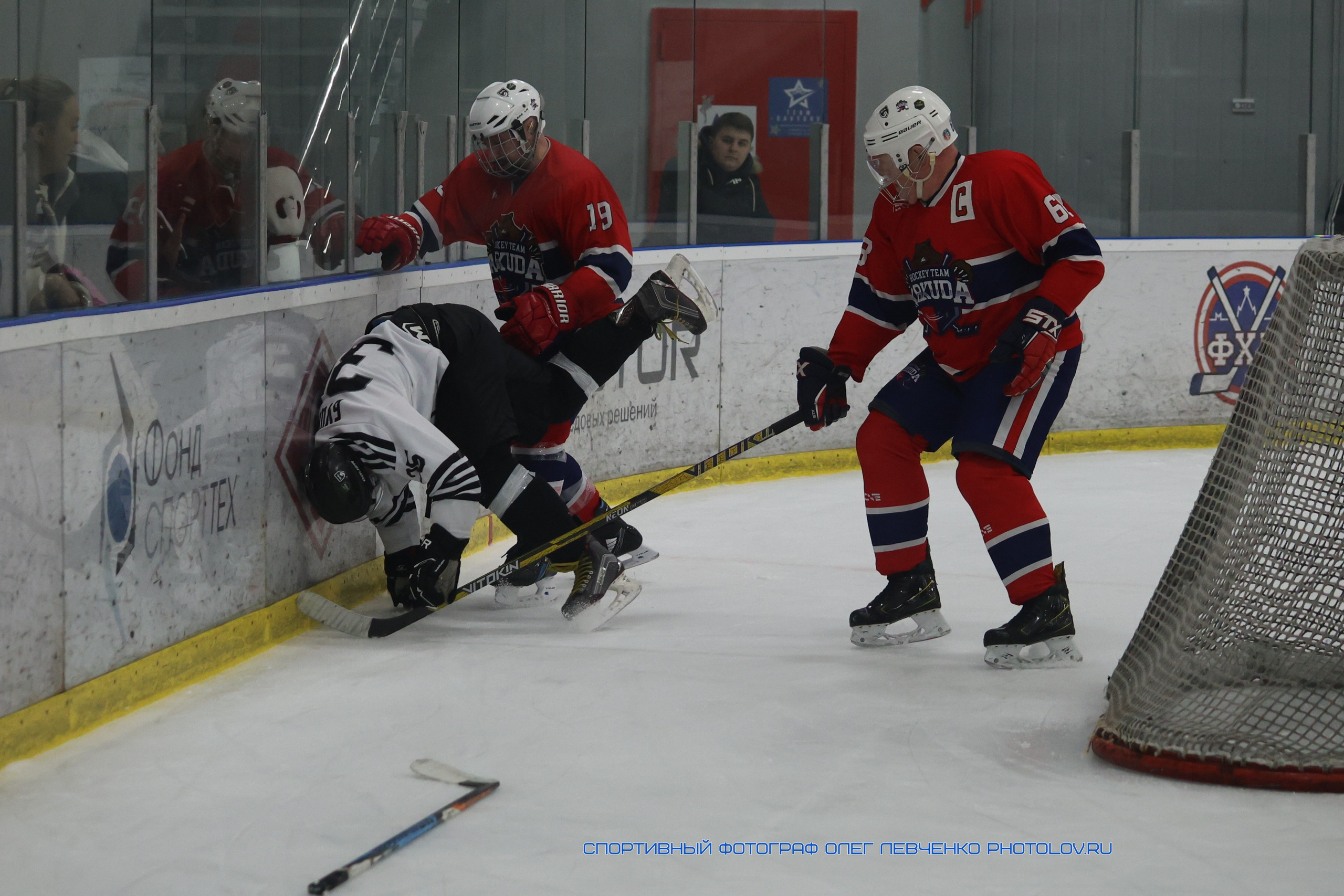 Борьба хоккеистов за воротами у бортика