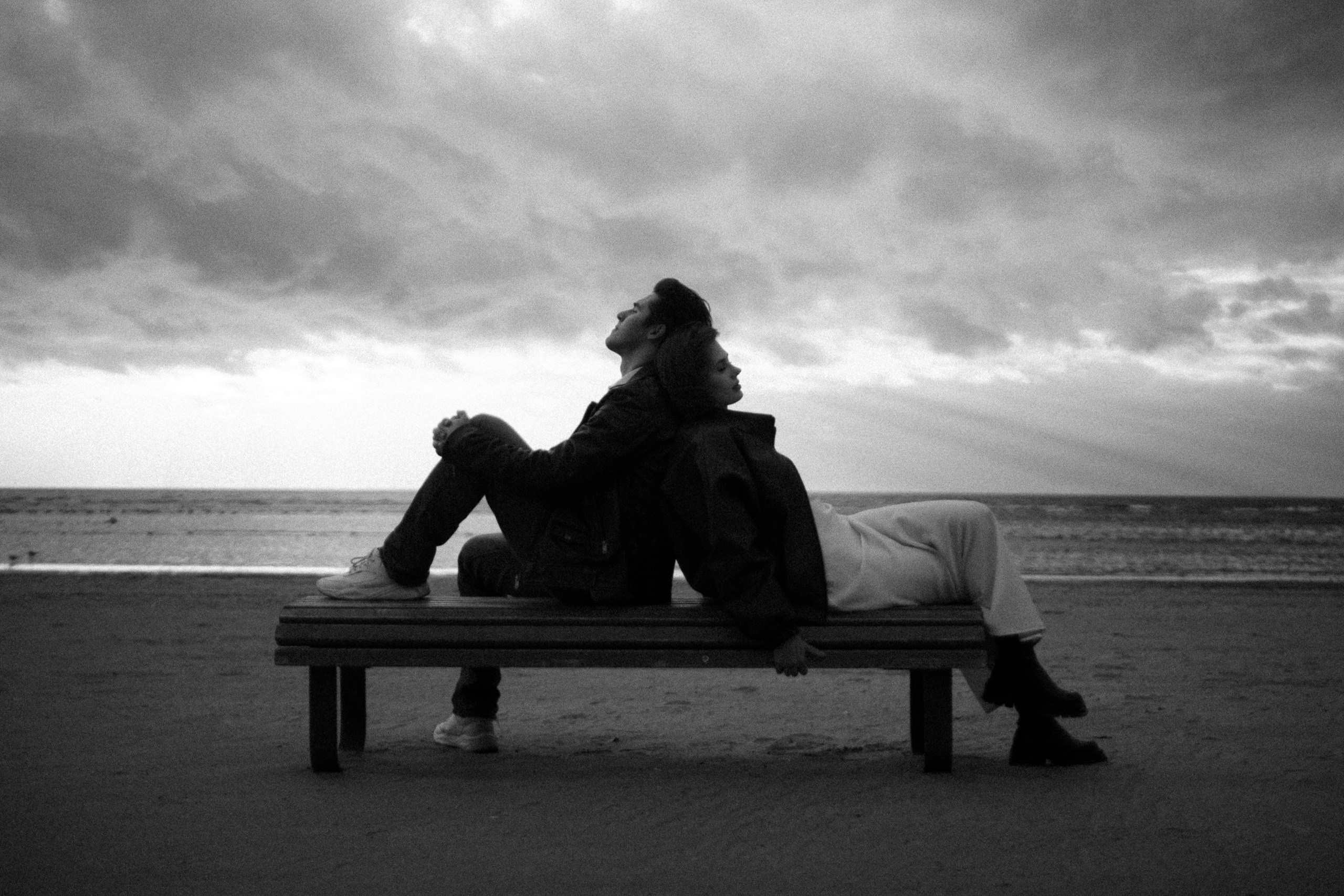 Пара сидит на лавочке у воды — чёрно-белый кадр с видом на Финский залив