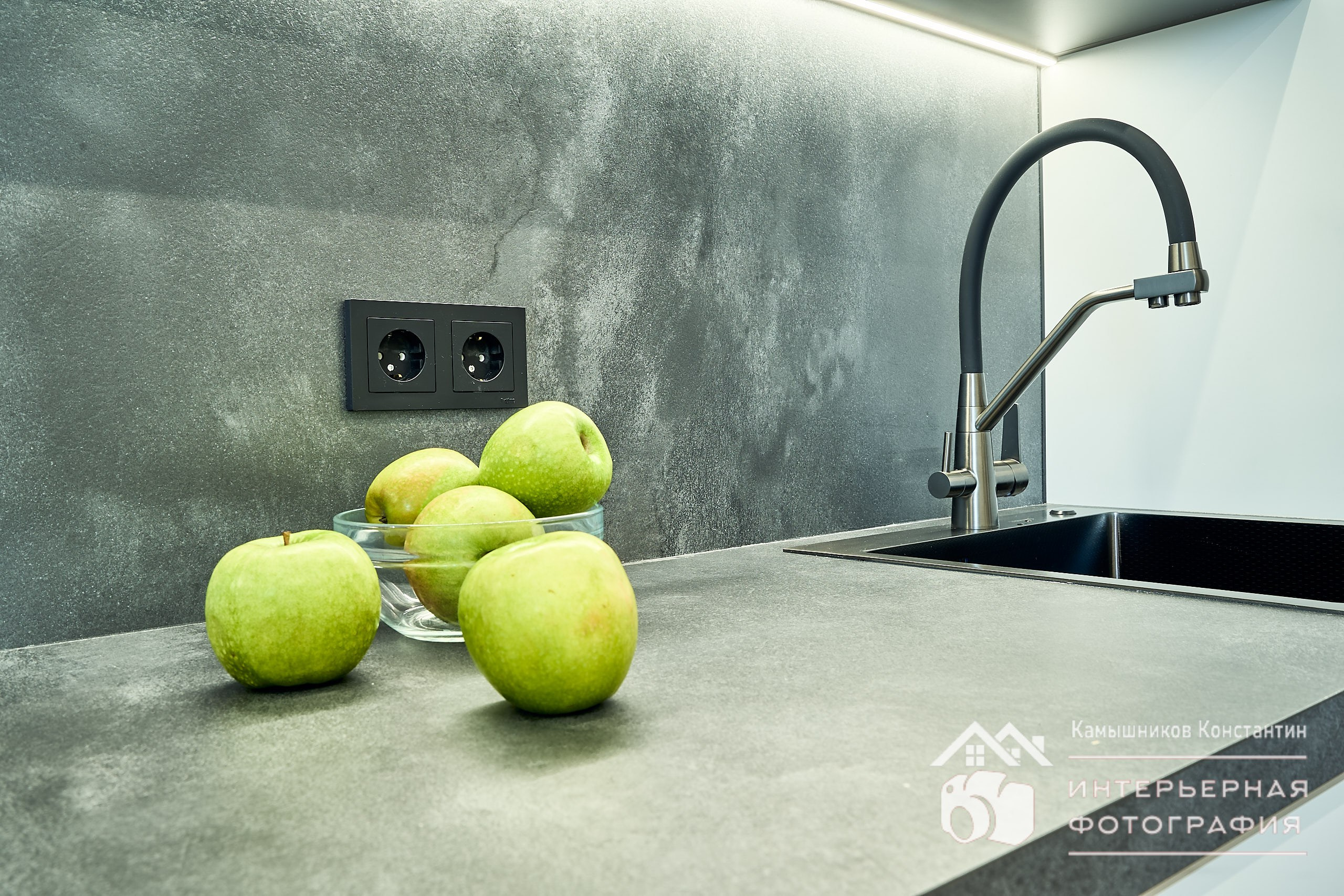 Интерьерная фотография с яблоками на разделочном столе и кухонным краном на заднем плане в жилых апартаментах ЖК Метрополия в Москве