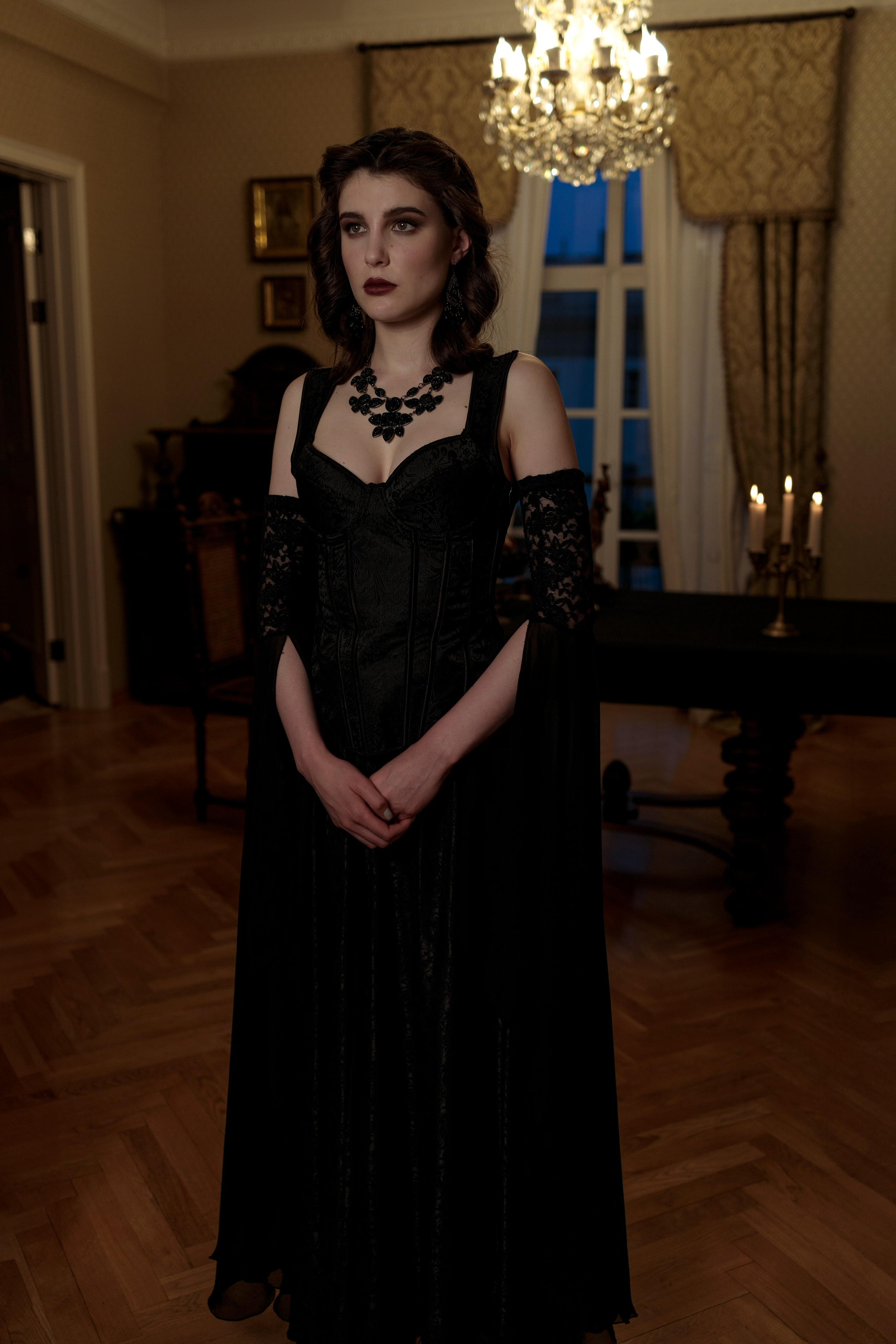 Девушка стоит в полный рост, руки сложены, сморит вперёд