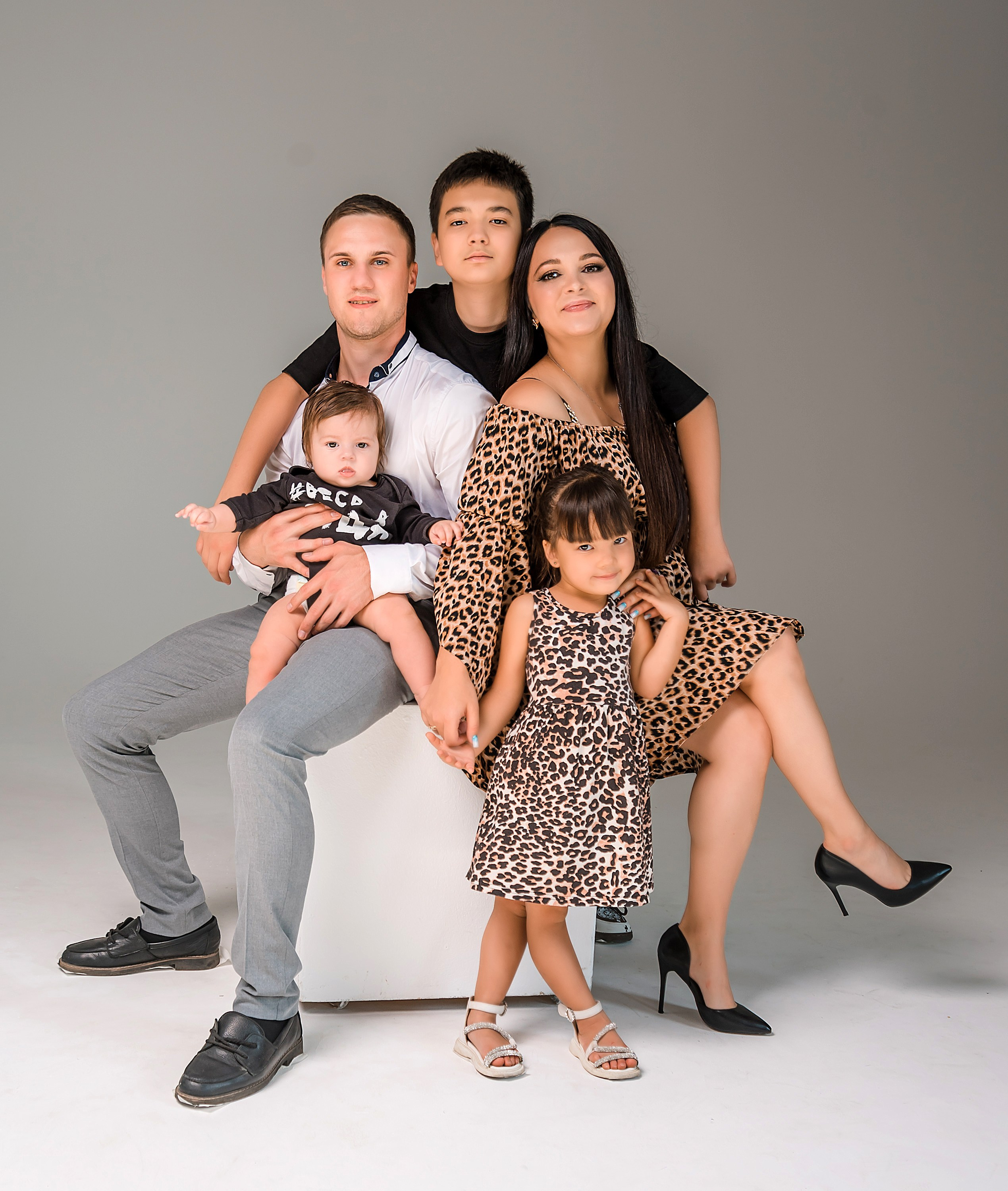 Семейная фотография на сером фоне.