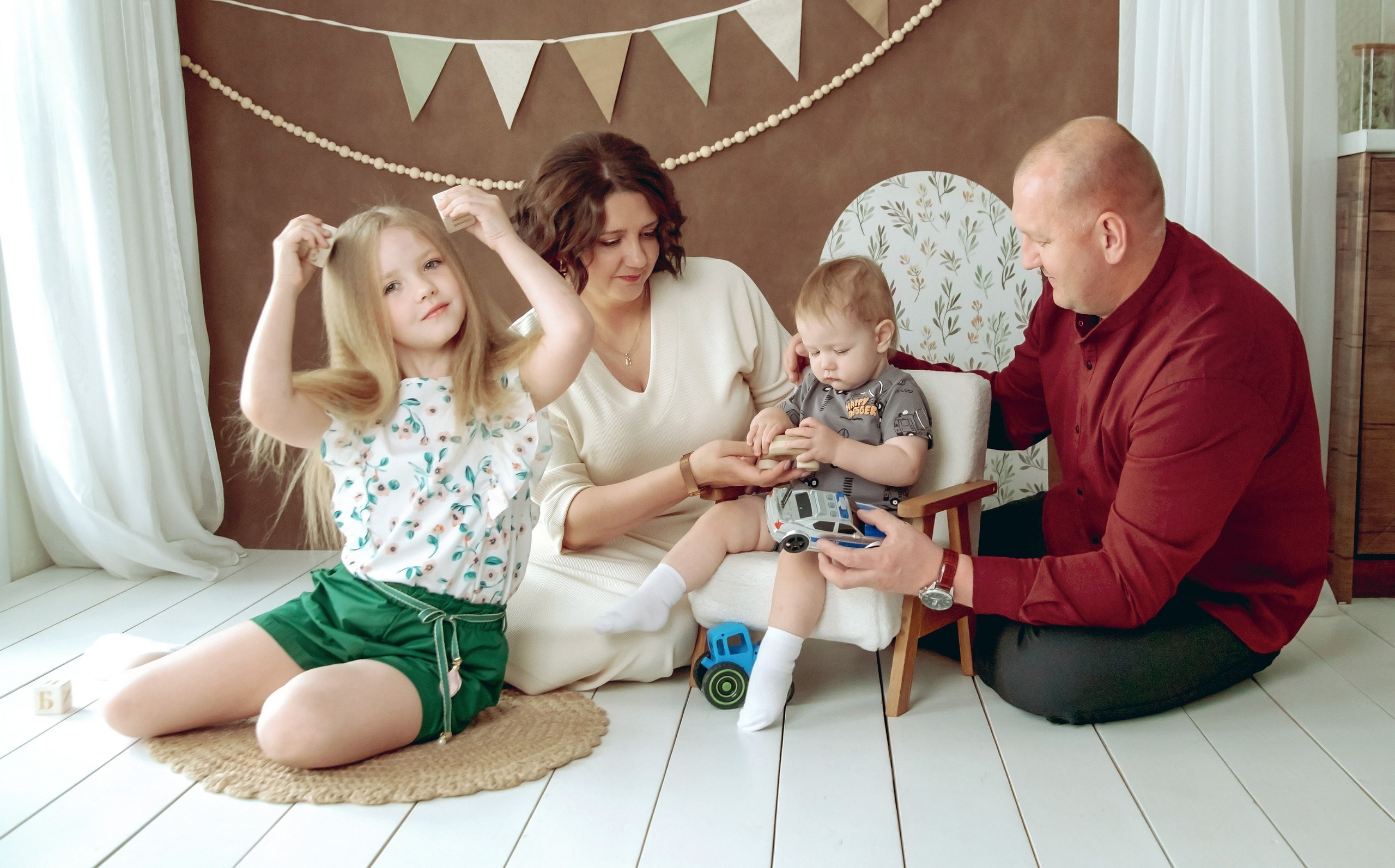 Семейная фотосессия в студии - вся семья сидя на полу