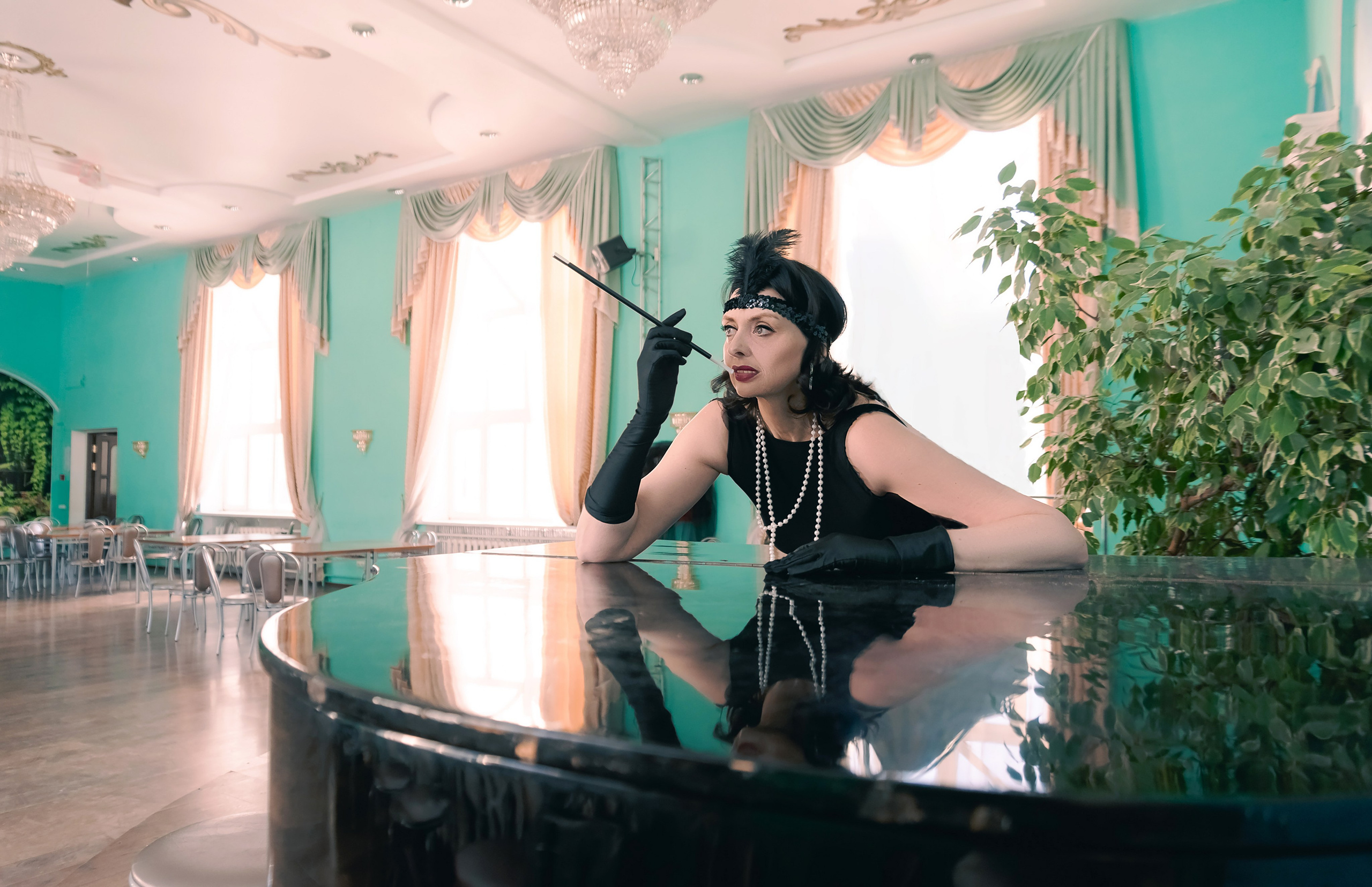 Девушка в стиле ретро, винтаж, Гэтсби около рояля смотрит в зал.