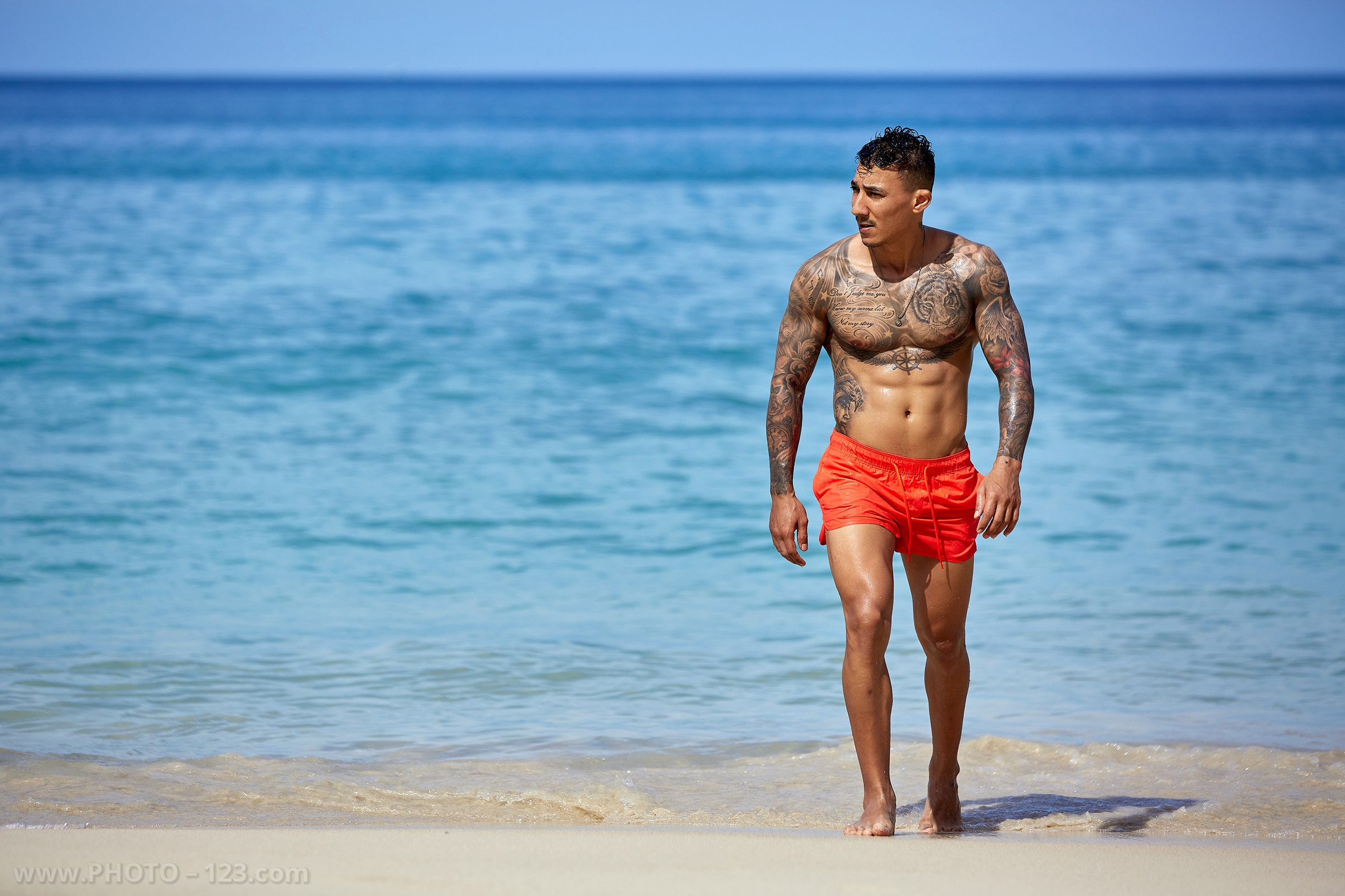 Full-length shot of a muscular man walking out of the sea captured by Nha Trang photographer