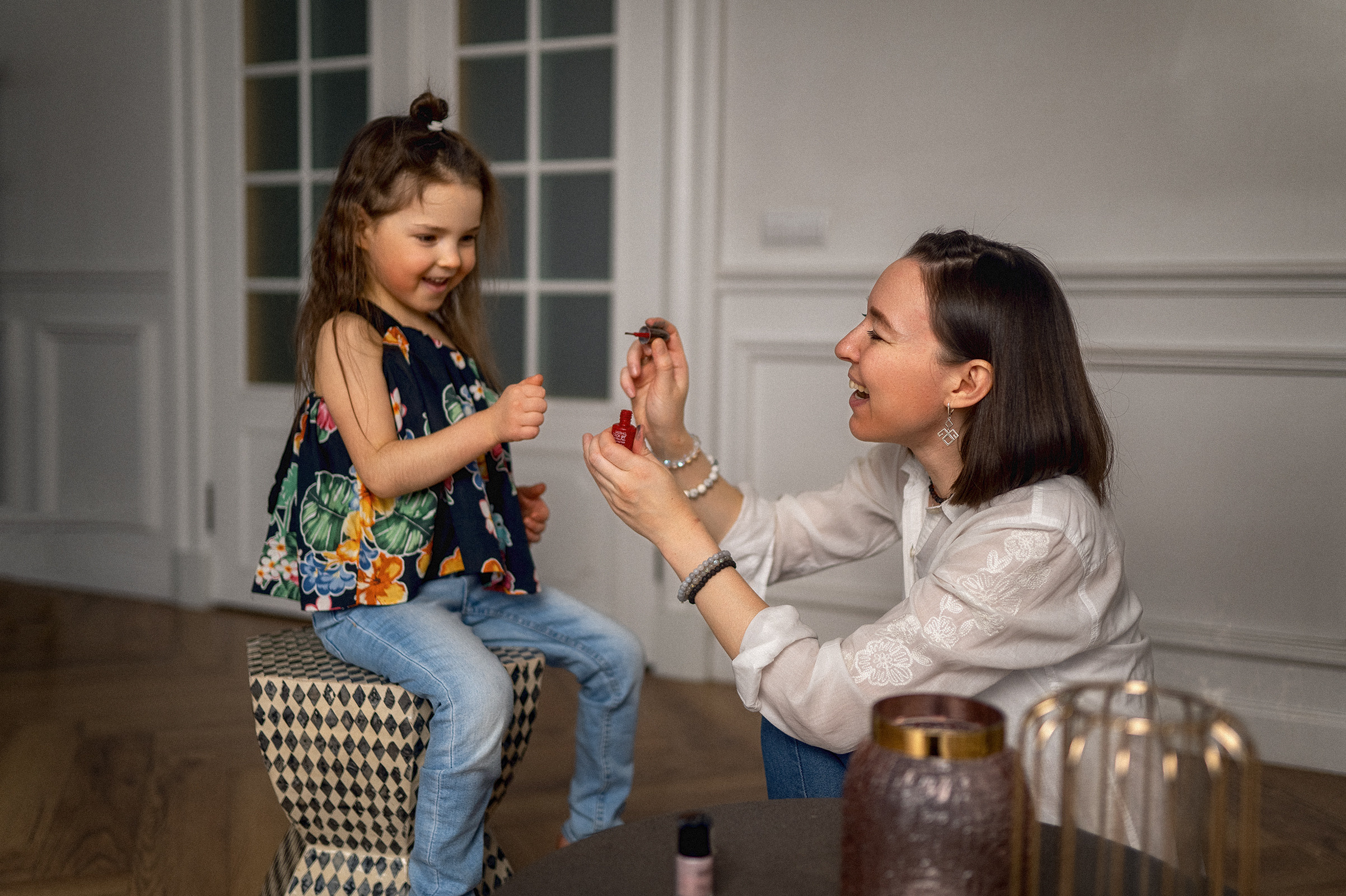 Дочка с мамой в синих джинсах делают макияж