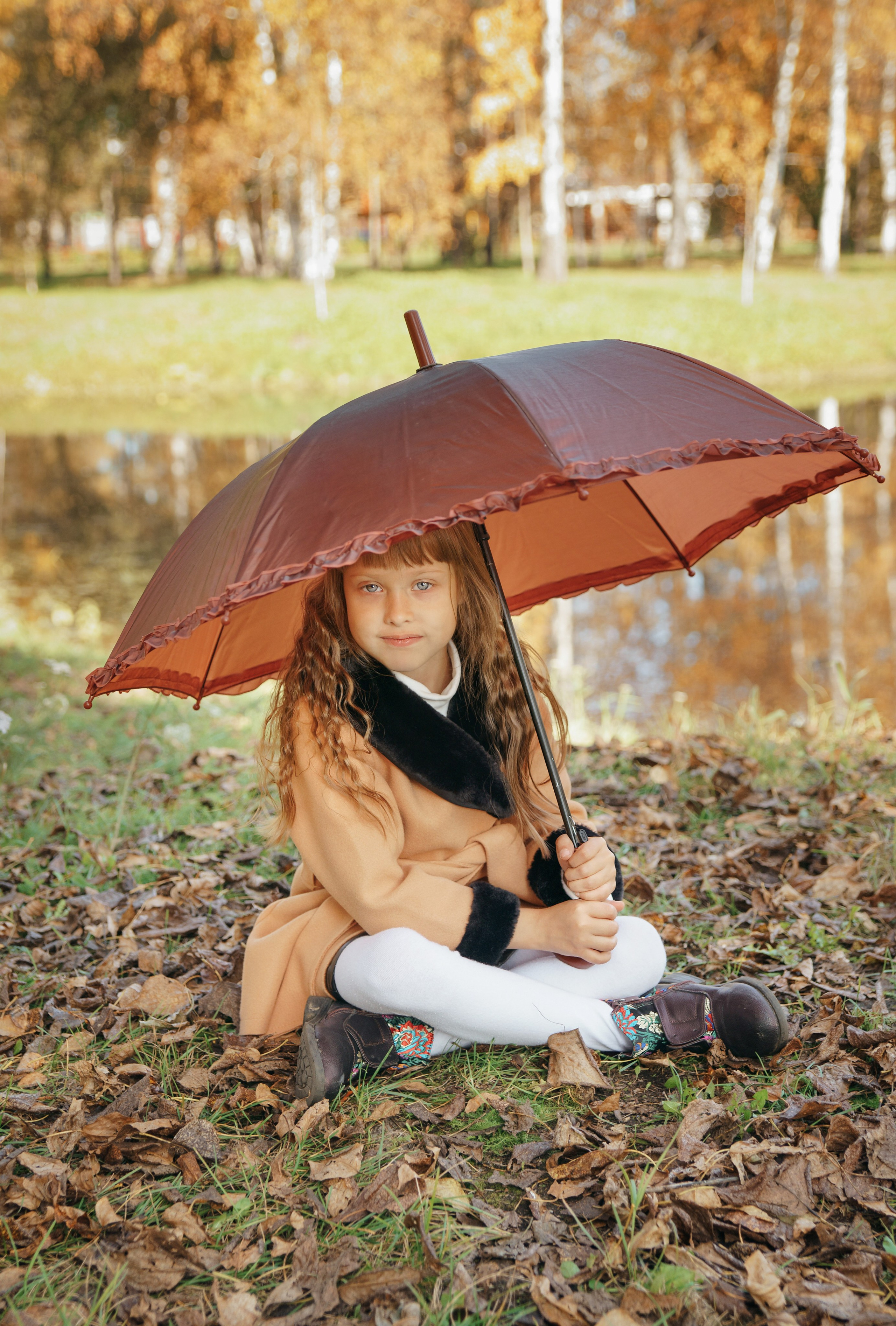 Семейная осенняя фотосессия в парке - девочка сидя под зонтом