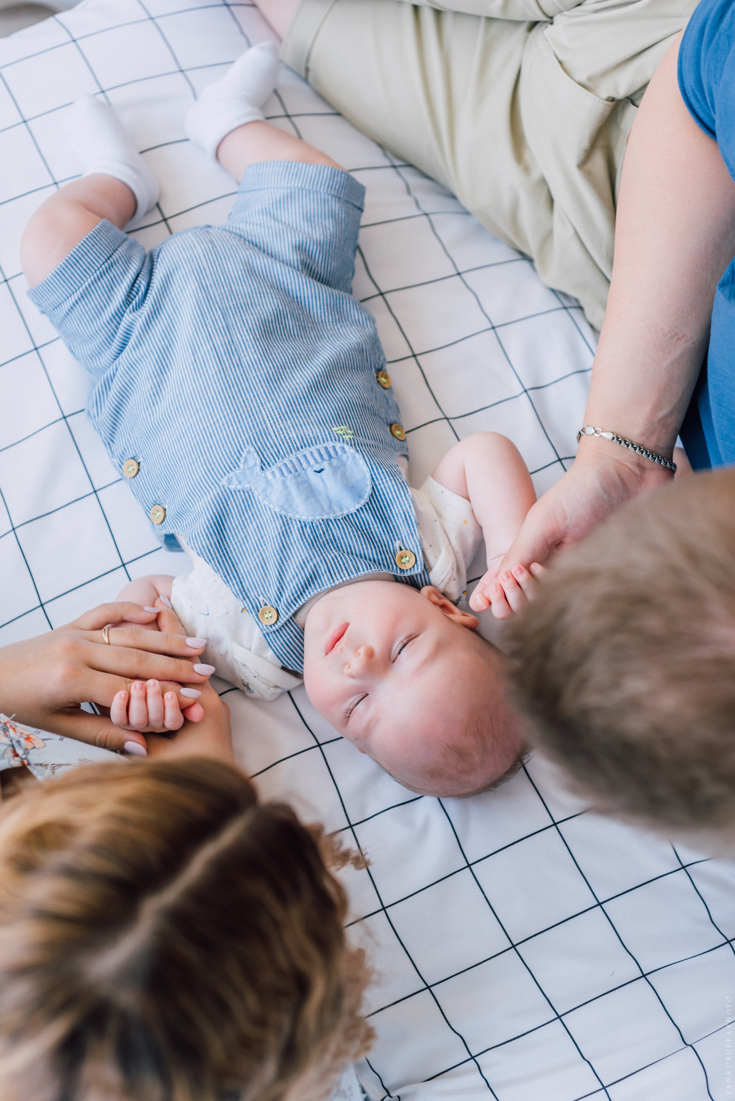Папа, мама и сын лежат на кровати вид сверху