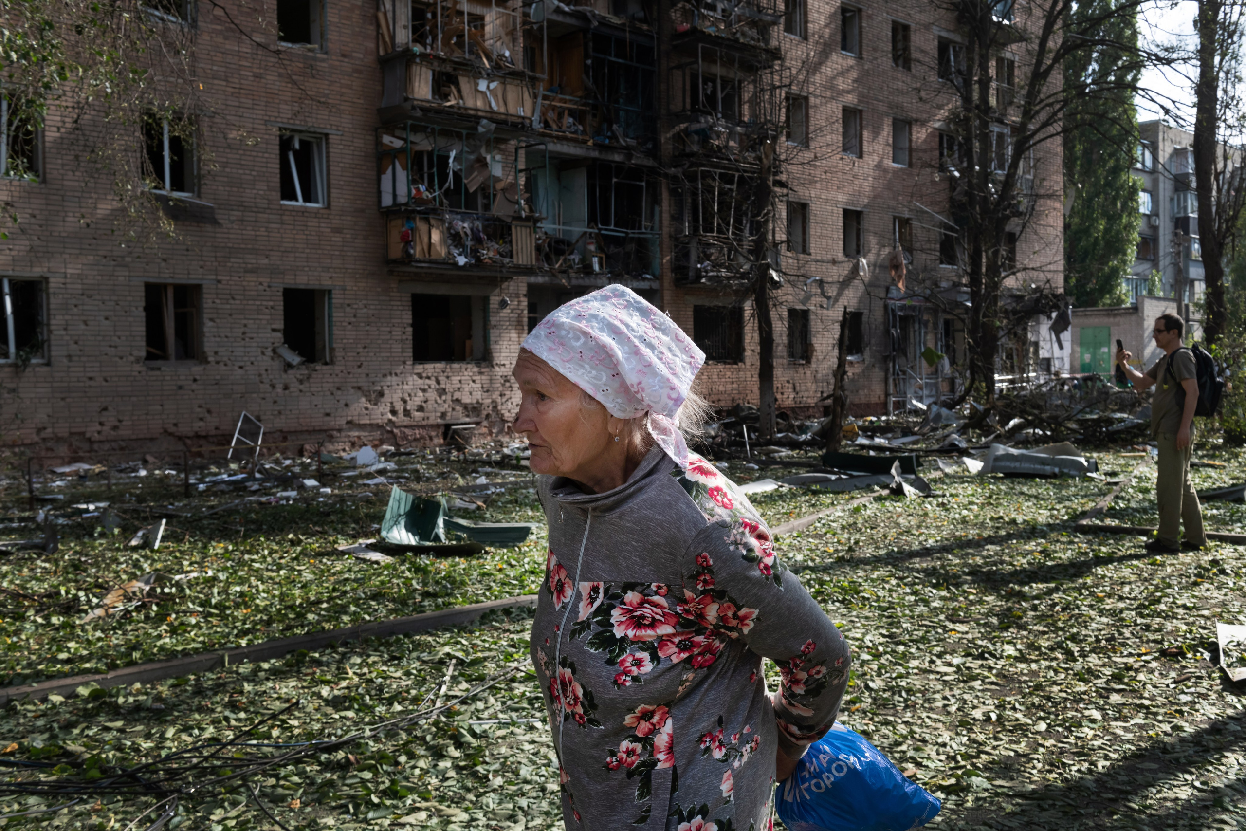 An elderly woman walks past an apartment building damaged after shelling by the Ukrainian side in Kursk, Russia, Sunday, Aug. 11, 2024. (AP Photo)