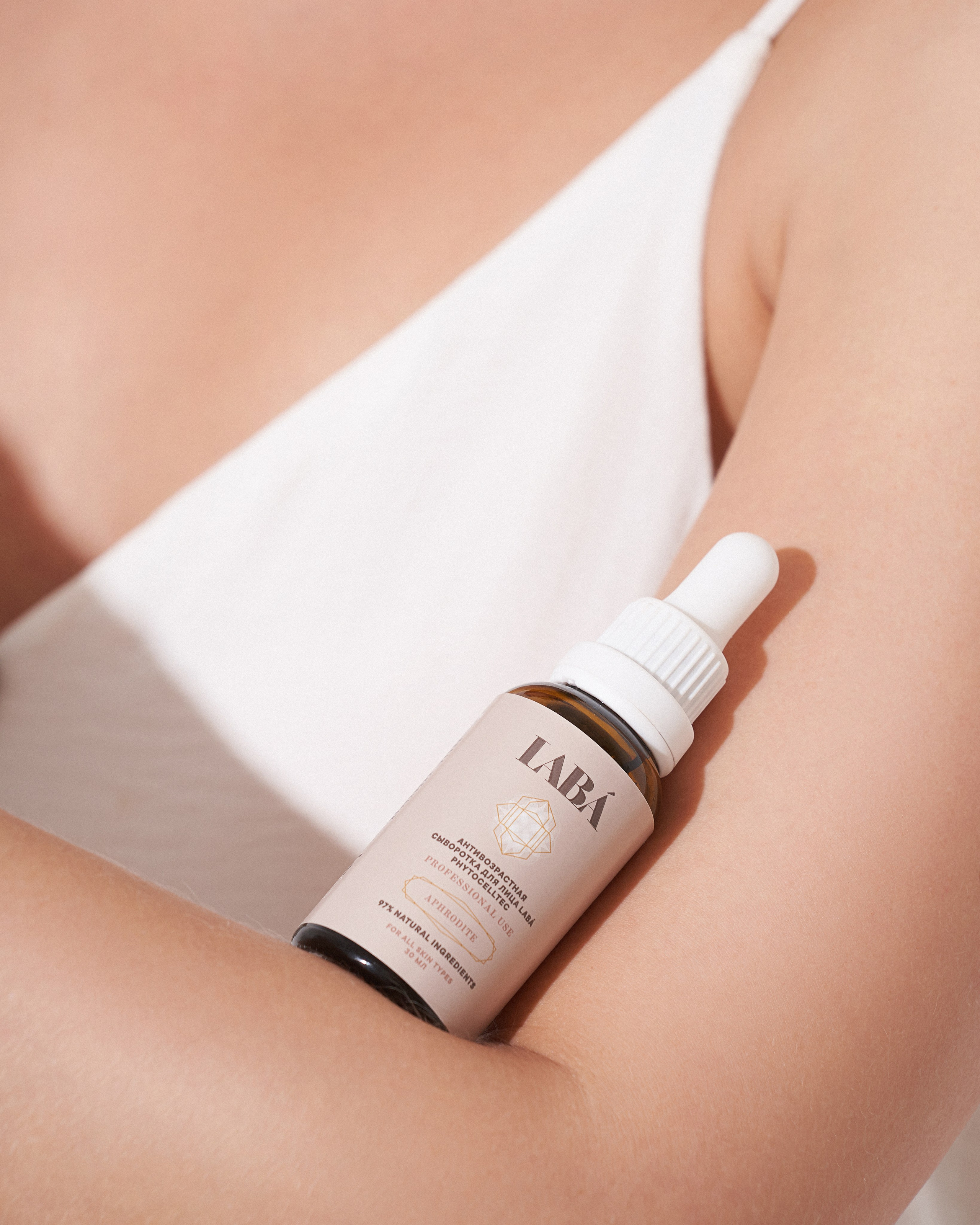 Банка косметики крупным планом на теле модели