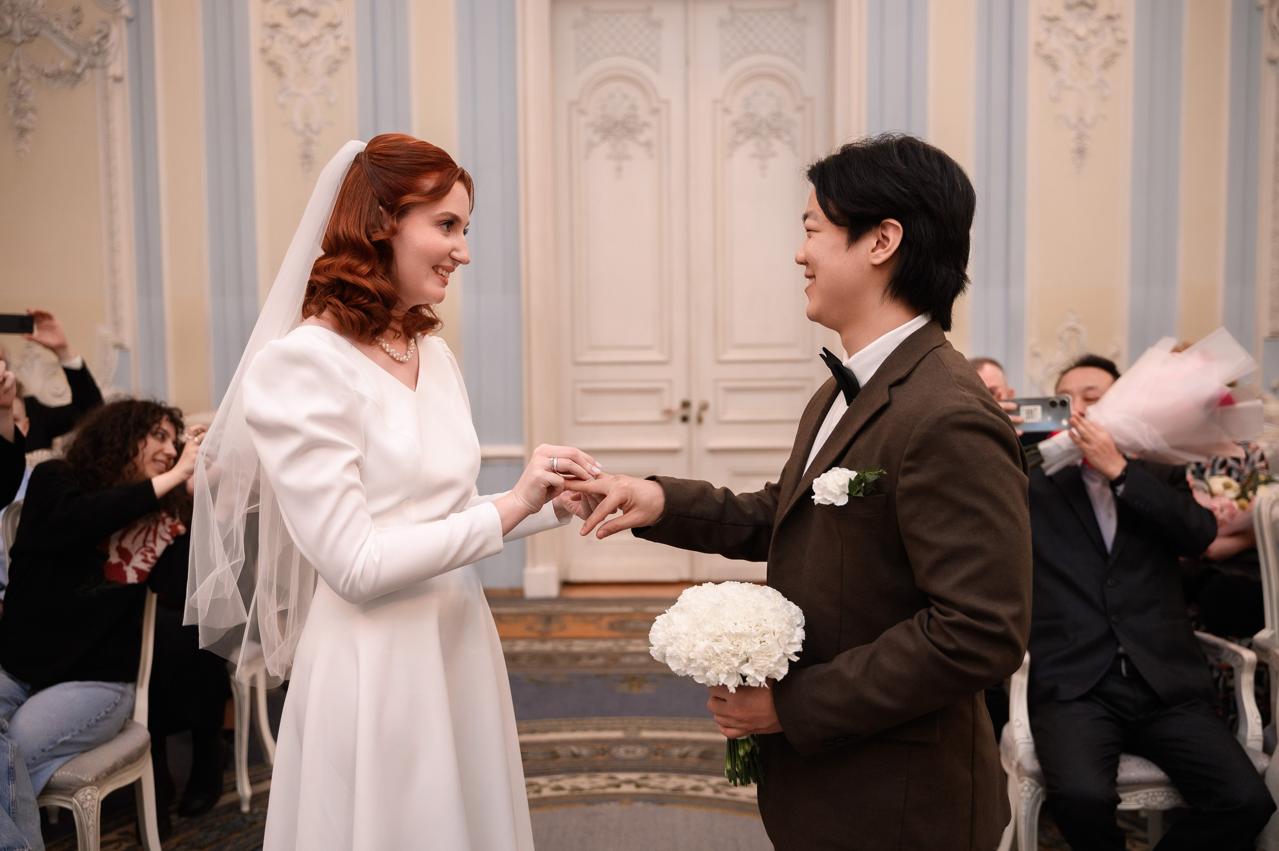 Свадебная фотосъёмка торжественной церемонии бракосочетания в интерьерах зала дворца.