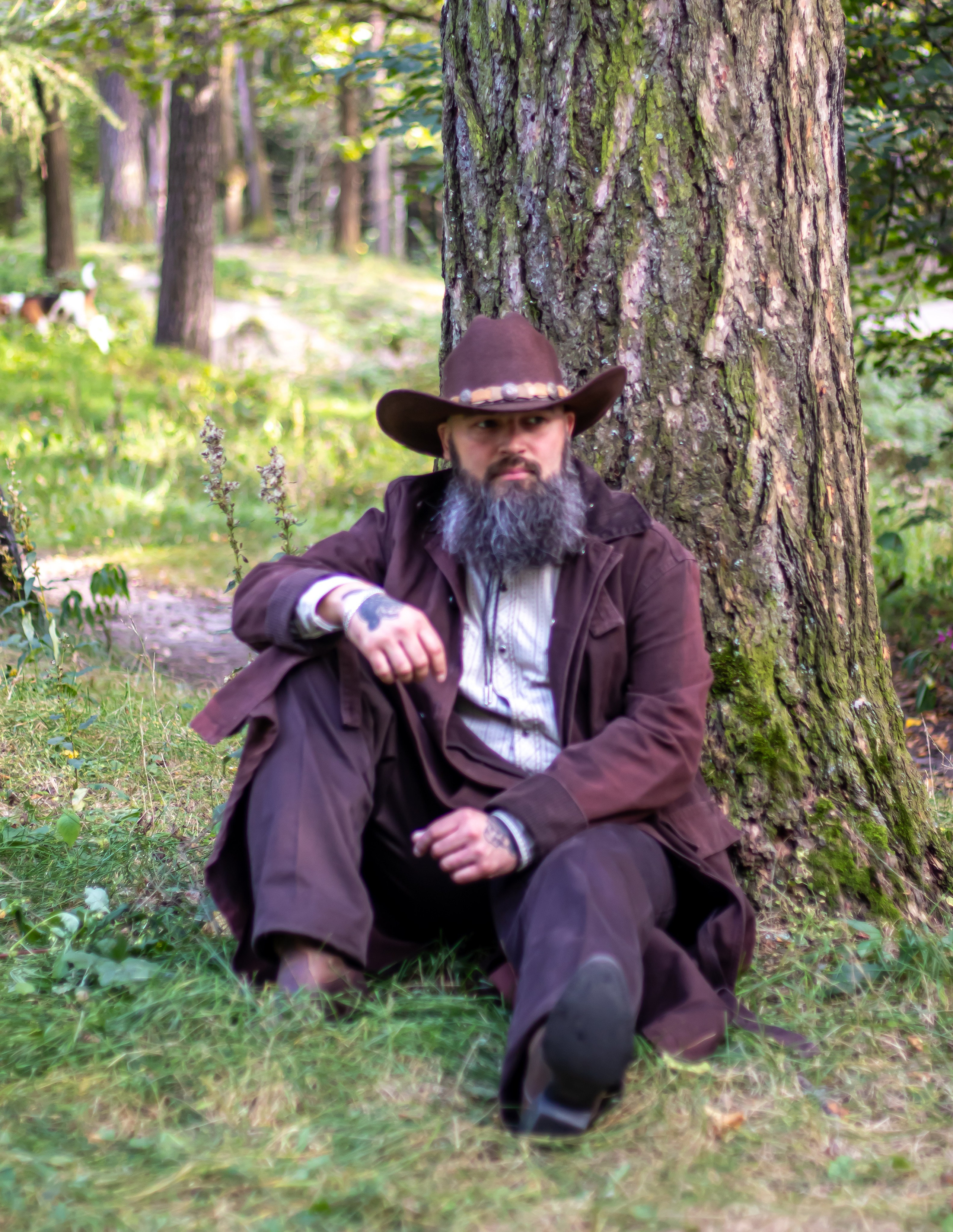 Мужчина в шляпе стоит у дерева — атмосферная съёмка