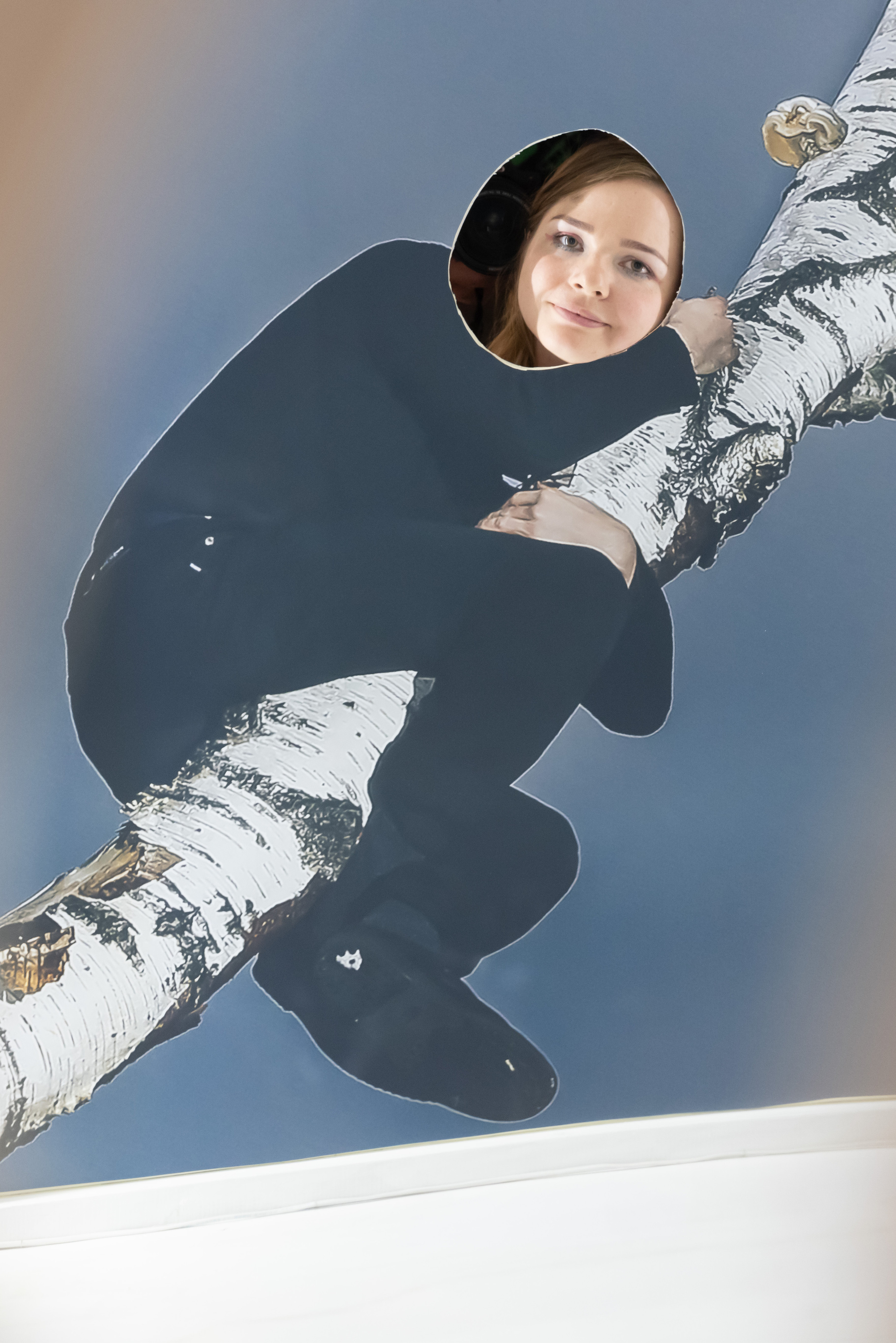 Человек в черной одежде висит на березе, обхватив ее плотно руками и ногами, находясь в опасности и без опоры. На месте его головы отверстие, в которое любой желающий может поместить свою голову. Автор работы (современное искусство): визуальная художница Ольга Михальчук.