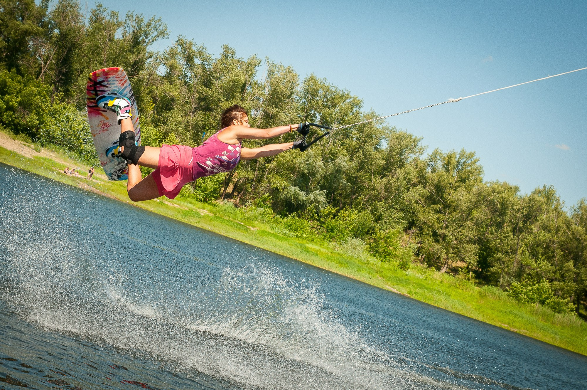 Девушка на вейкборде взлетает над водой