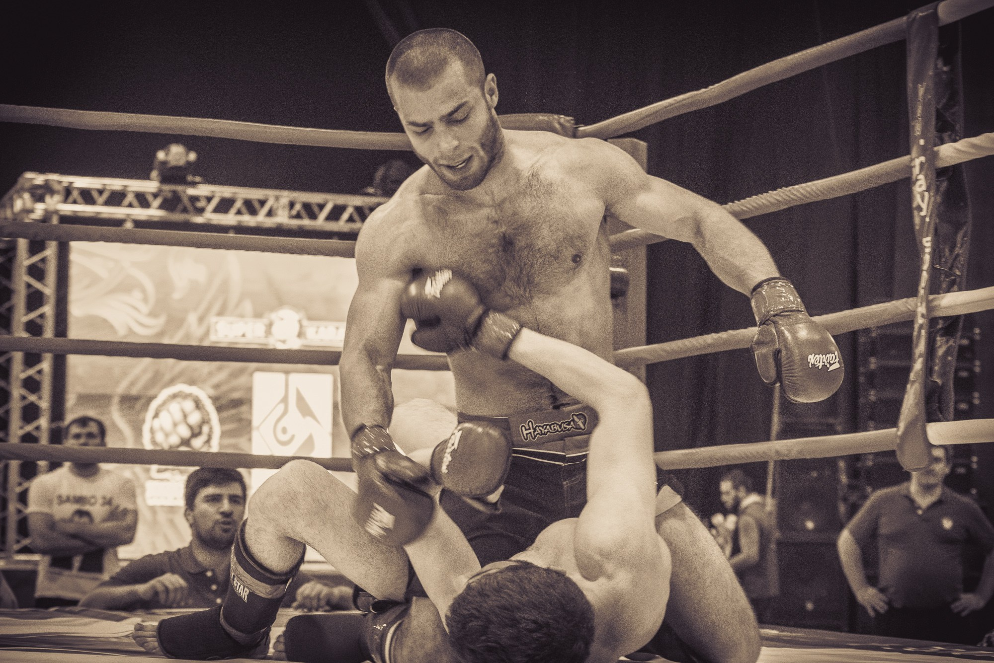 Боец сидя на сопернике наносит ему удары