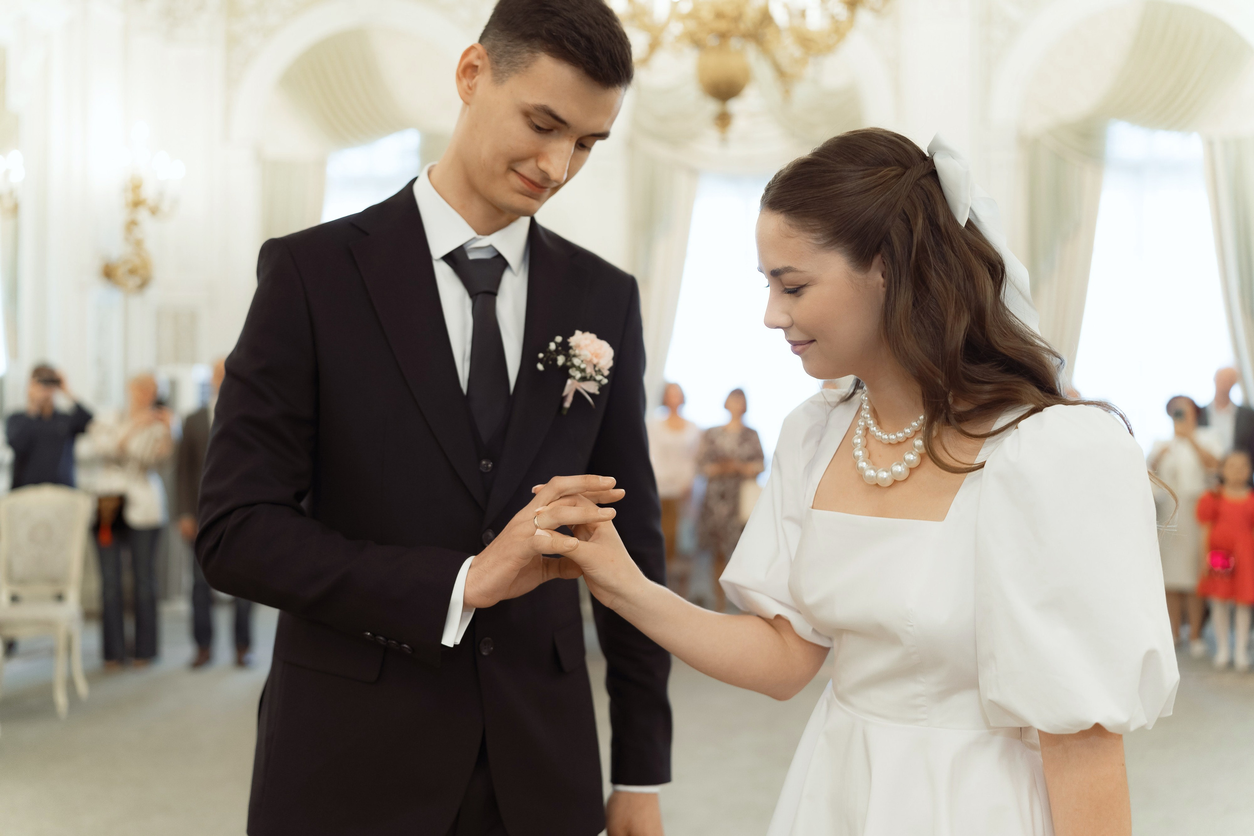 Невеста надевает кольцо жениху, трогательный кадр во время регистрации