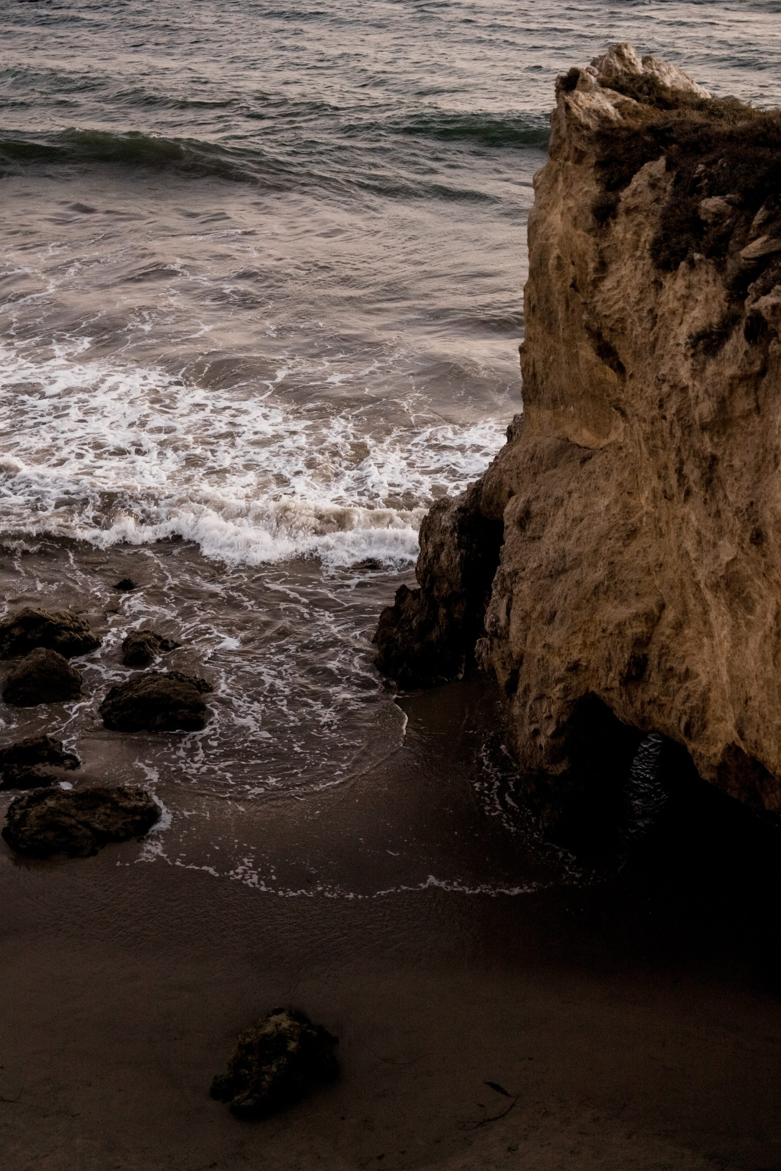 Dramatic shot of a rocky coastline at golden hour, showcasing natural beauty and serenity.