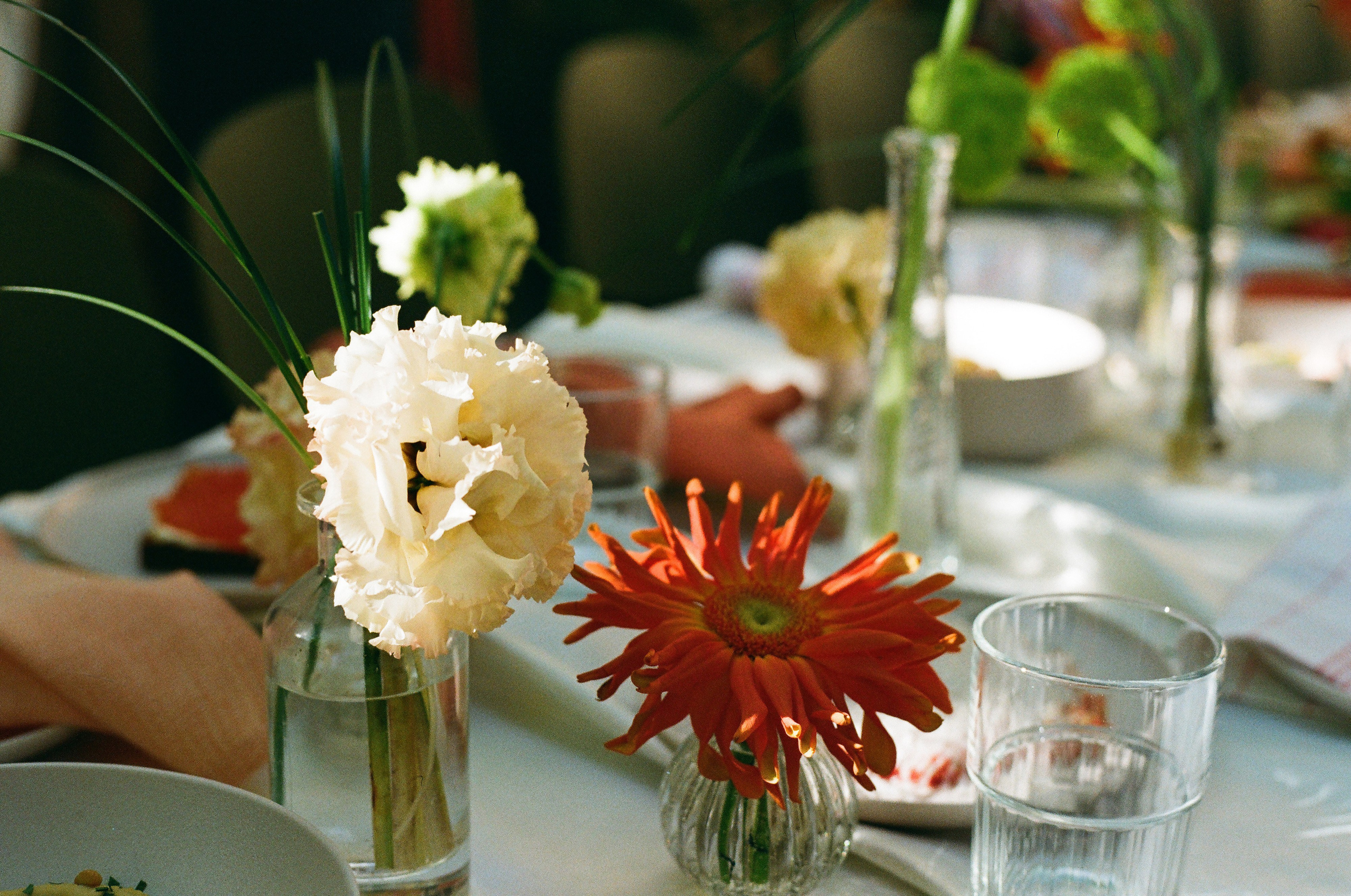 Букет георгинов и бокалы шампанского на свадебном столе, плёночный кадр Kodak Gold 200 в Ivory Garden