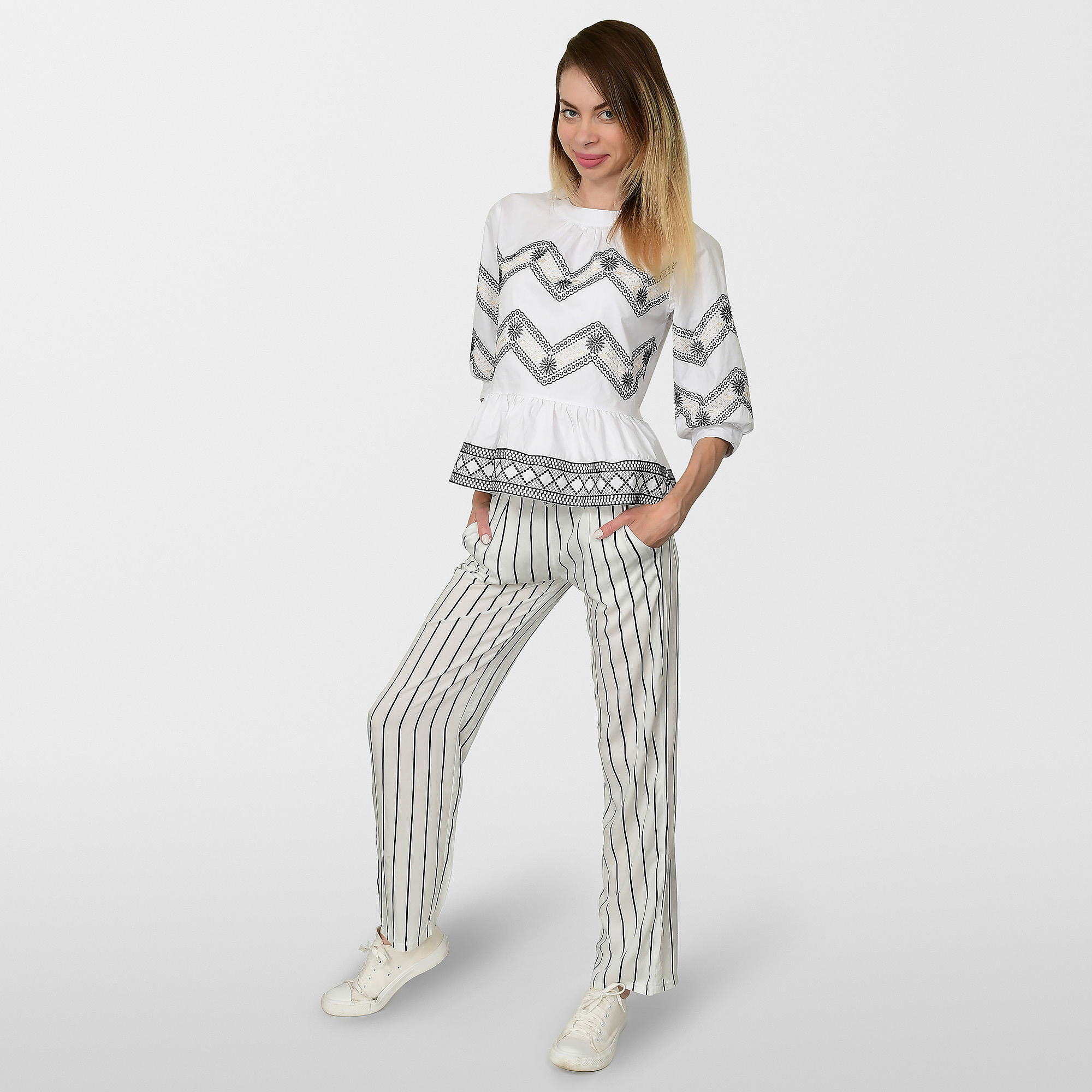 Девушка в белой одежде стоит на фоне с тенью.