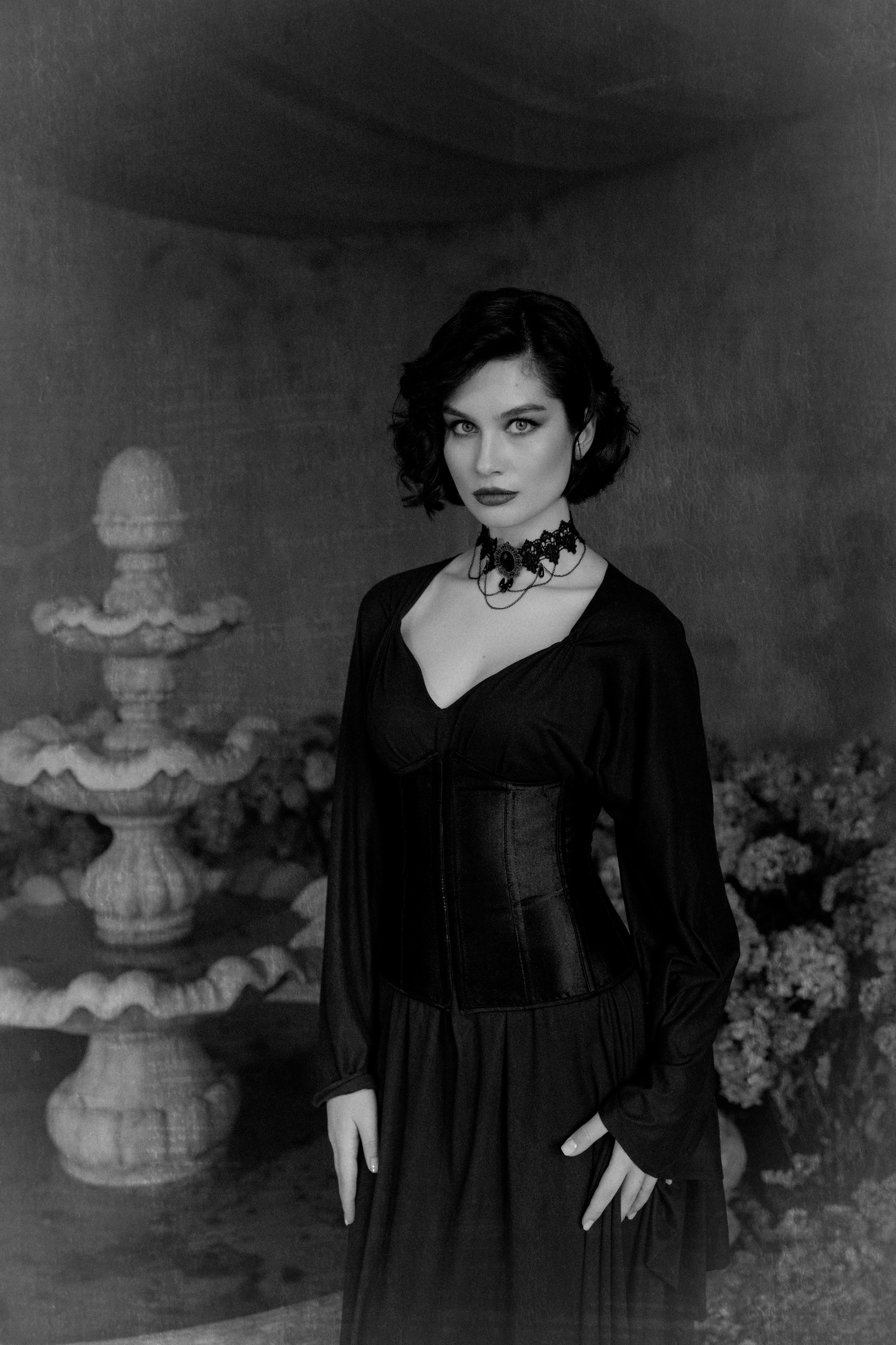 Девушка стоит около фонтана, взгляд направлен прямо в камеру