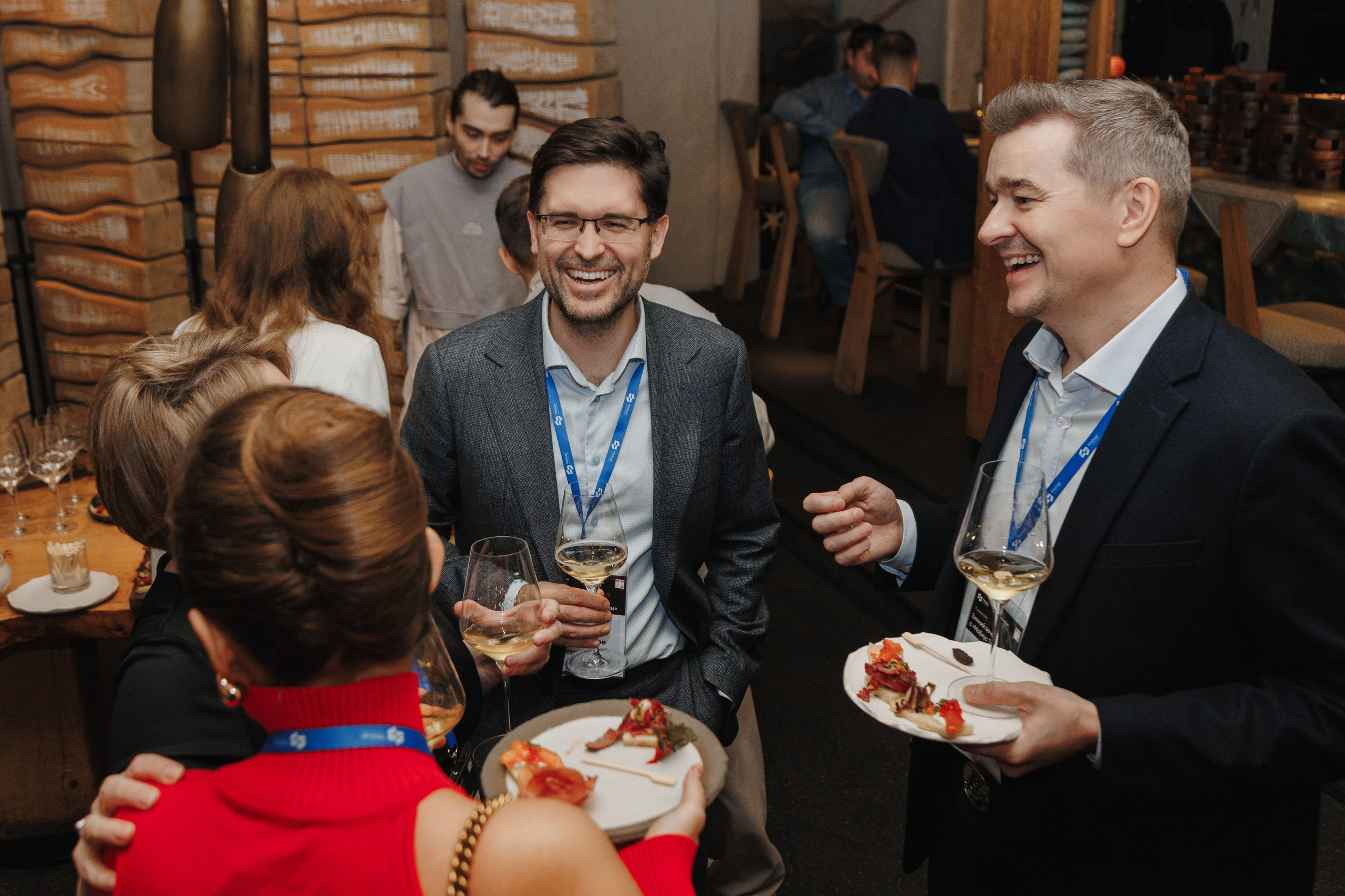 Неформальное общение: гости смеются и общаются во время фуршета на мероприятии.