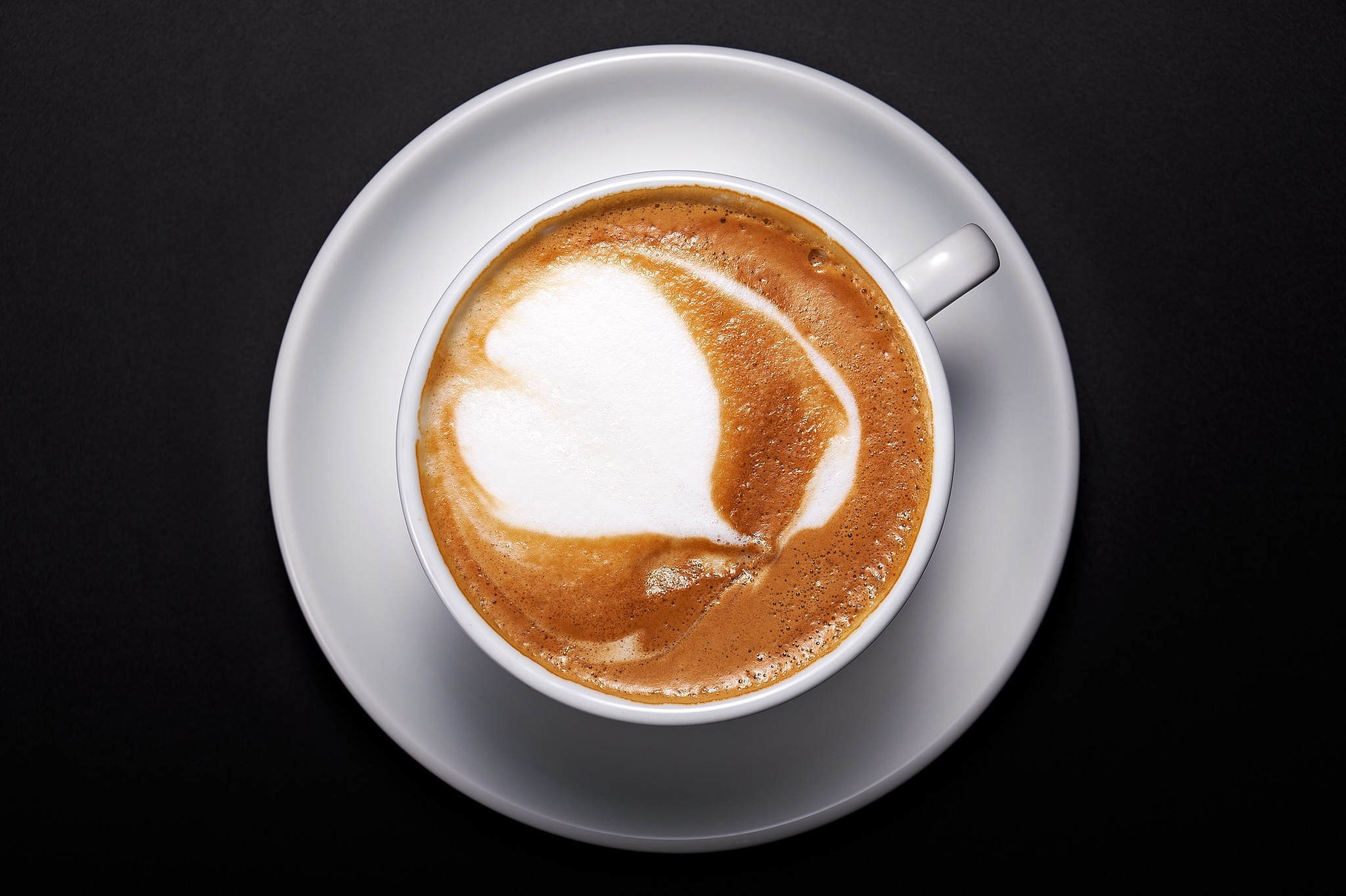 Капучино с рисунком сердечка, съёмка на чёрном фоне