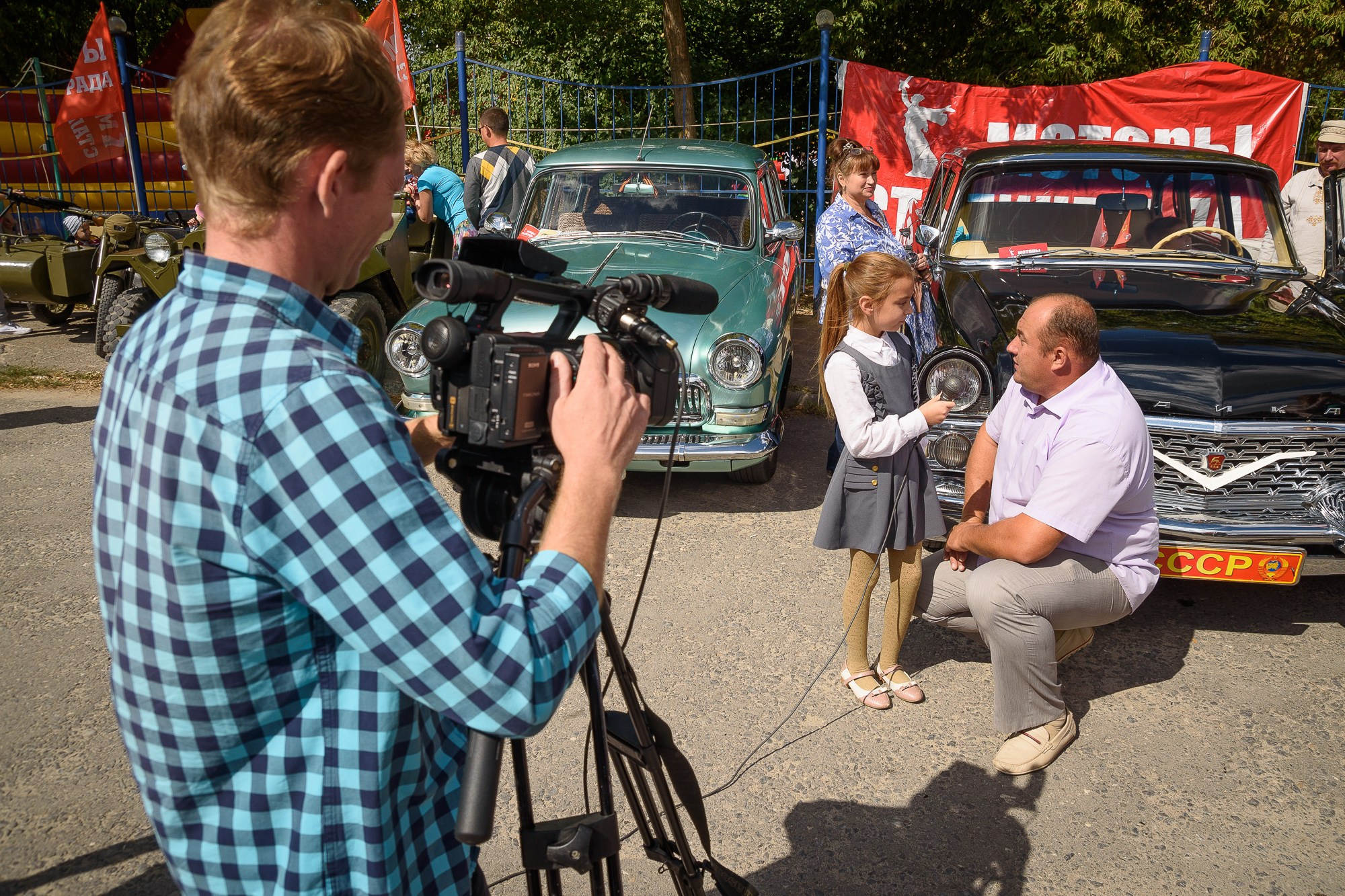 Девочка-журналист берёт интервью у мужчины, владельца ретро-автомобиля