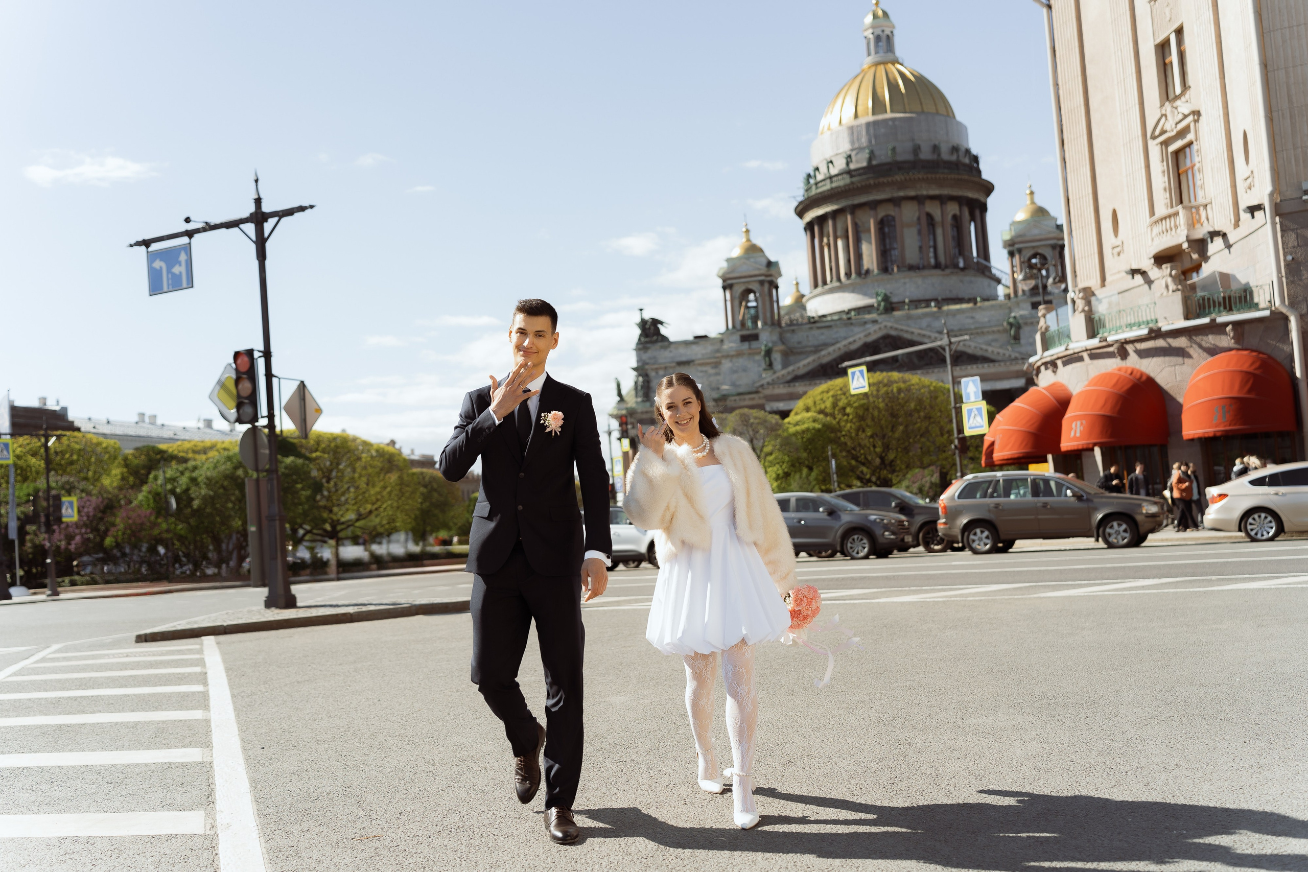 Жених и невеста в объятиях на фоне весеннего Петербурга