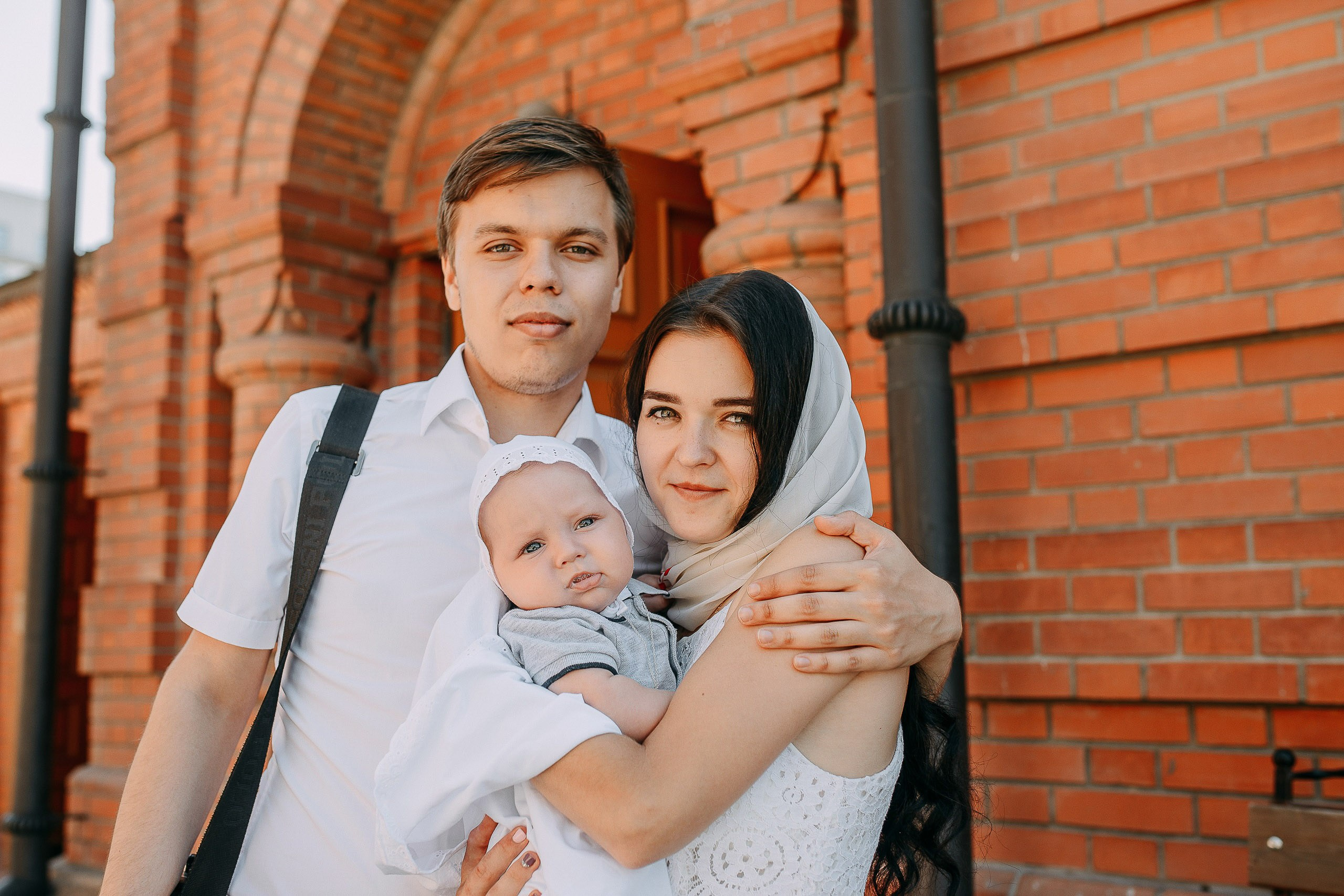 Услуги фотографа в церкви, художественный портрет мамы с сыном и папы во время таинства.