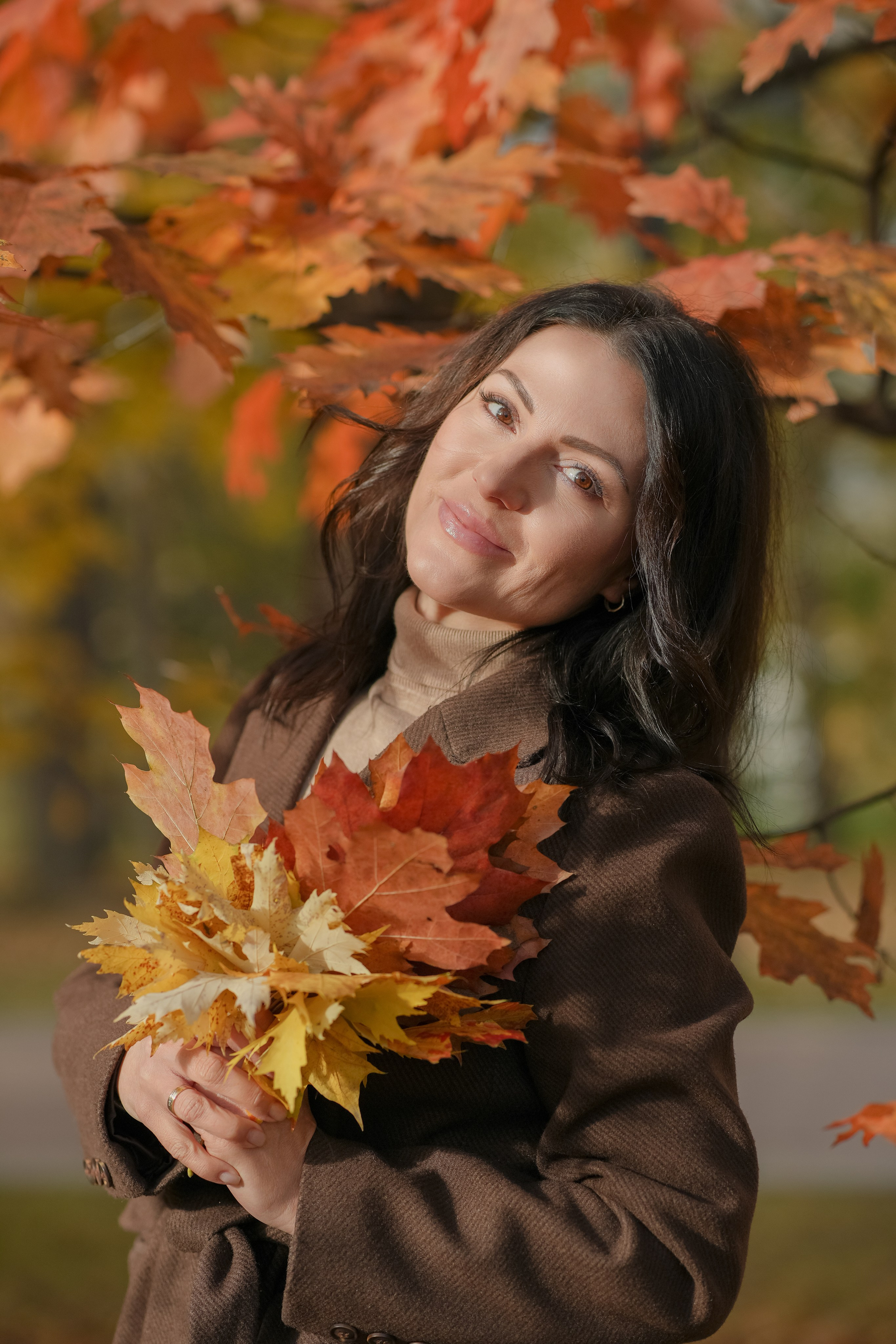 Красивая девушка брюнетка в парке золотой осенью