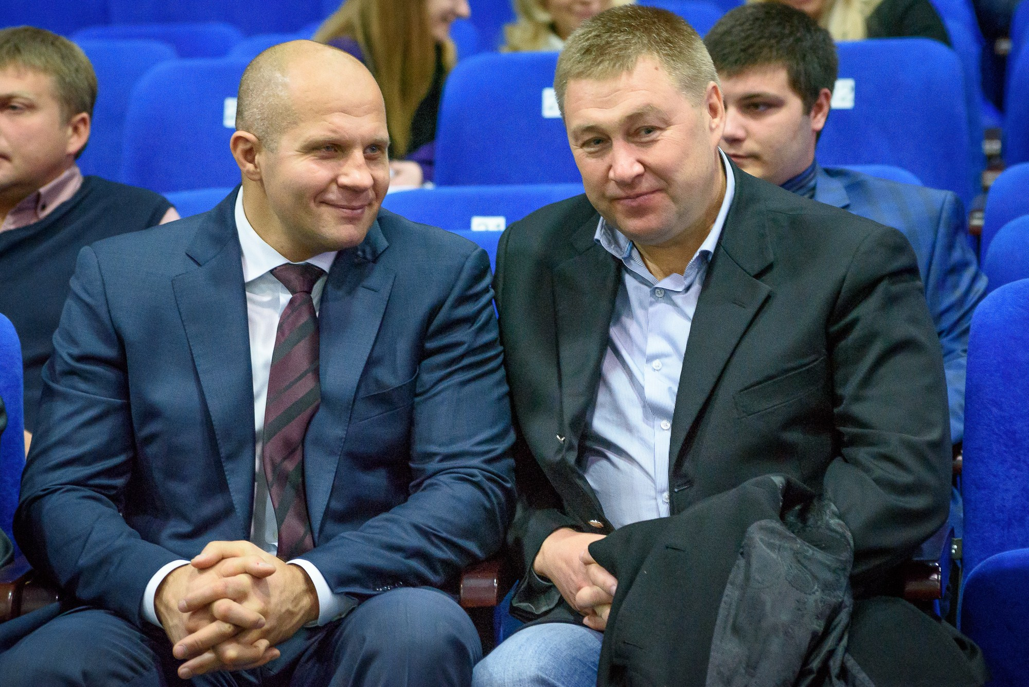 Фёдор Емельяненко сидит на синем кресле в зрительном зале на Кубке России по MMA