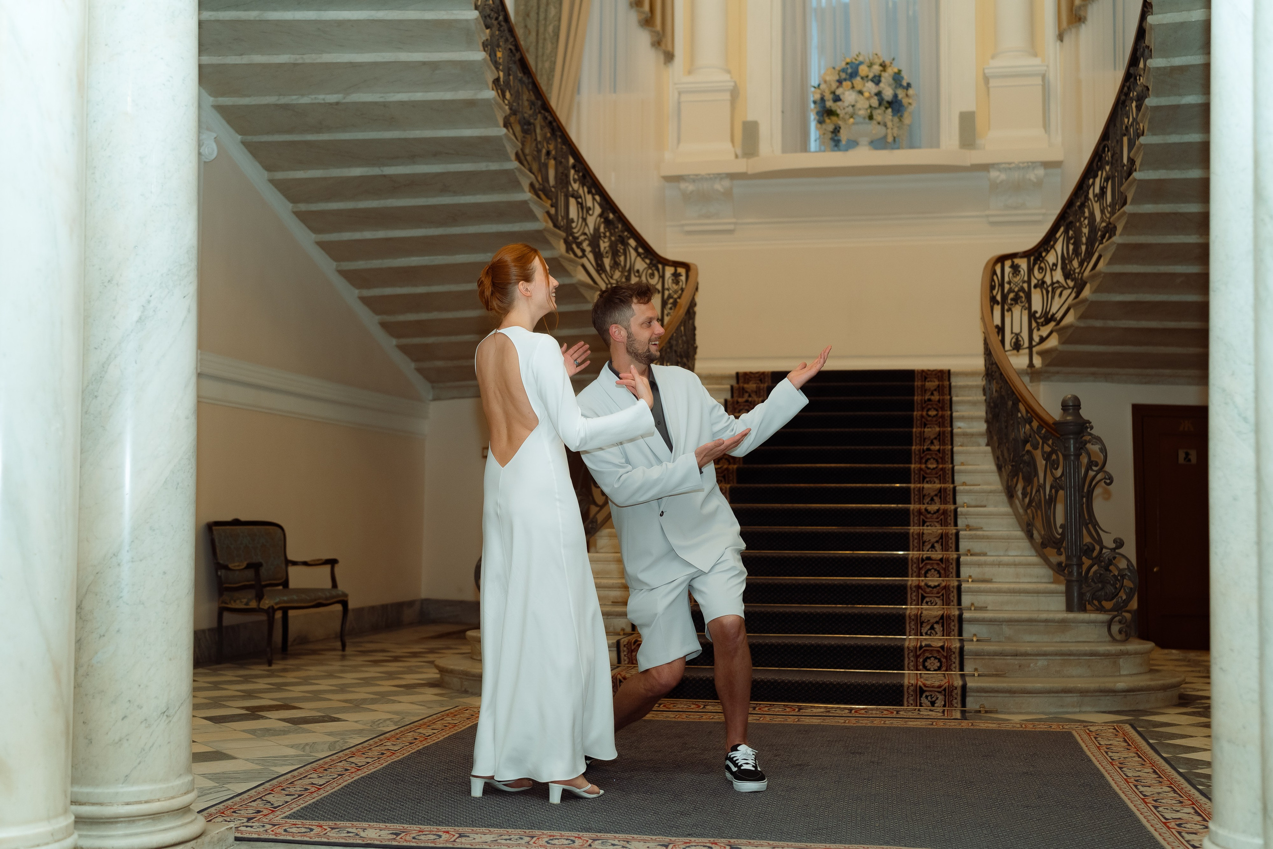 Мария и Евгений на парадной лестнице ЗАГСа с мраморными колоннами
