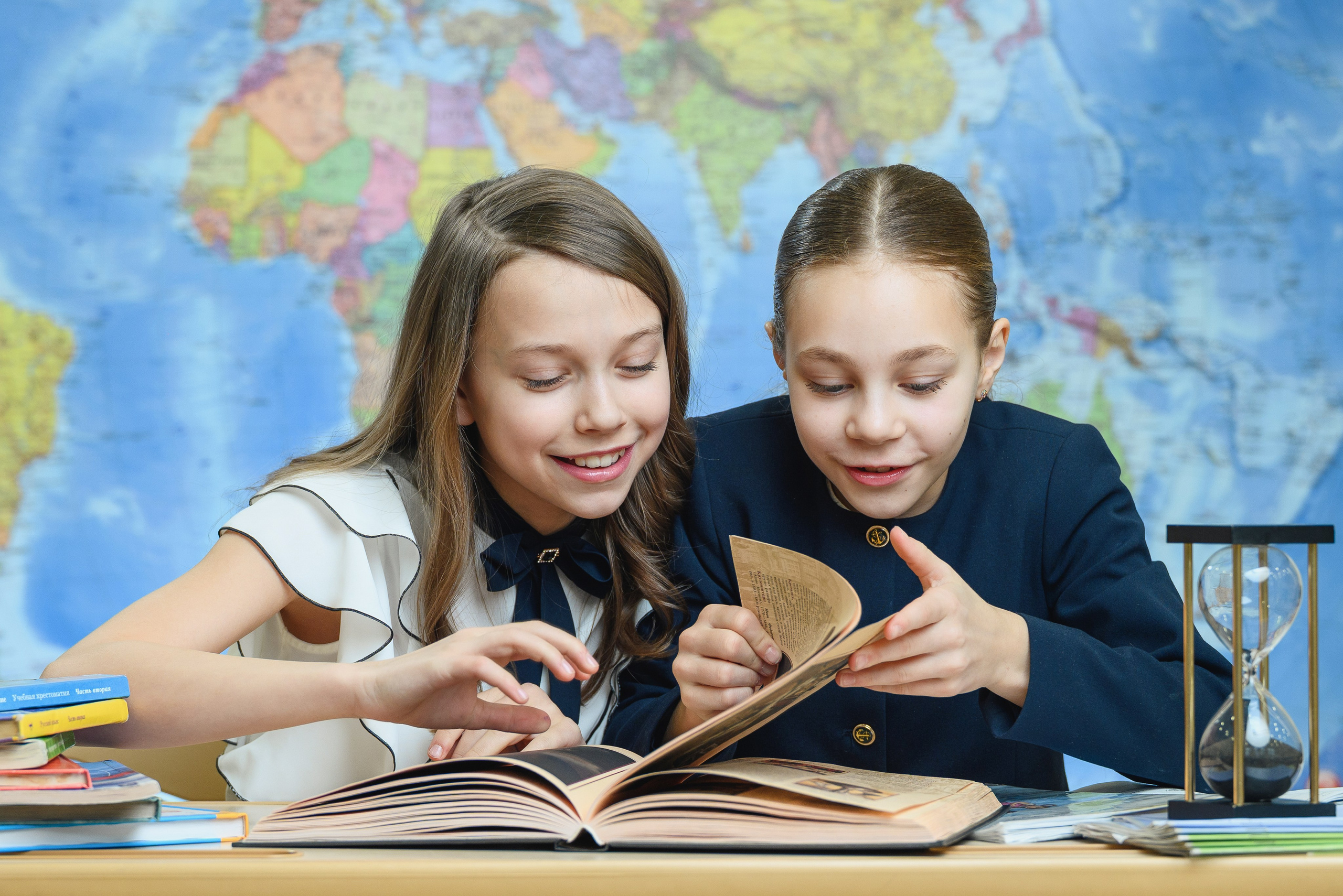 Две ученицы начальной школы выполняют задание за партой.