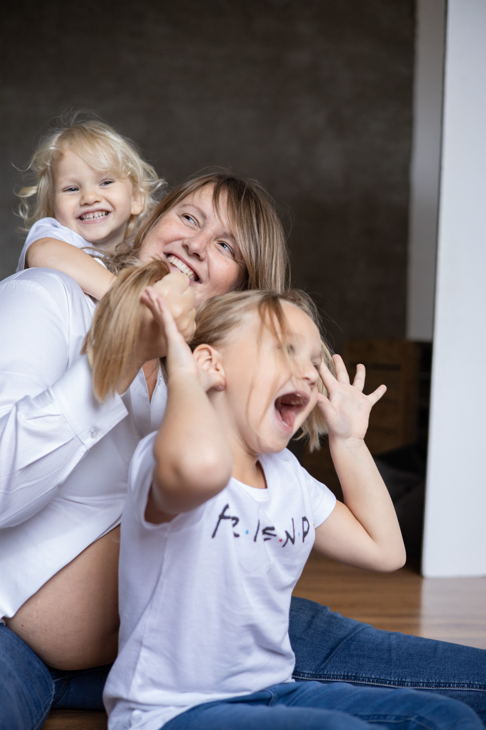 Двое детей и мама дурачатся, играют, сидя на полу. Семейная фотосессия Астрахань.