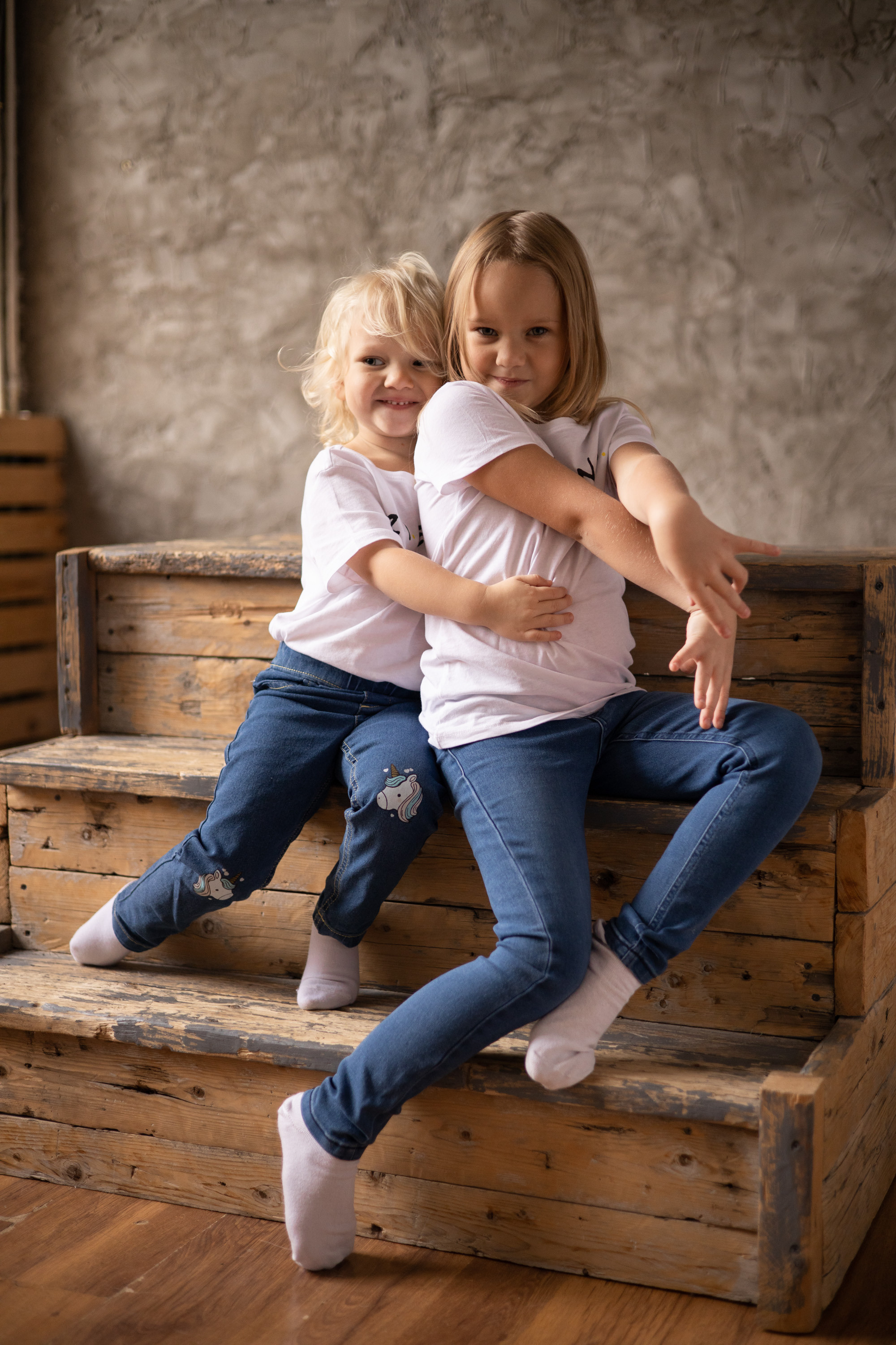 Двое детей сидят на ступенях, брат обнимает сестру. Семейная фотосессия Астрахань.