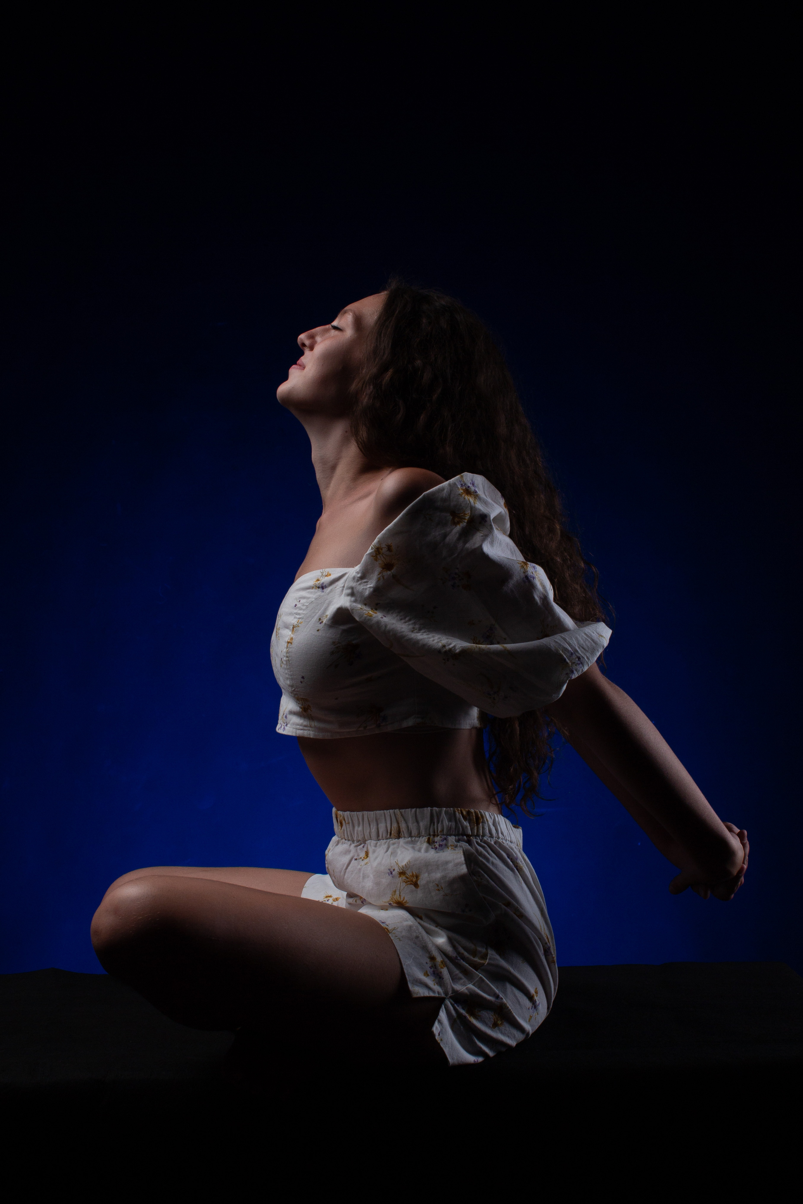 Девушка сидит, руки за спиной, ноги скрещены. Студийная съёмка Астрахань.