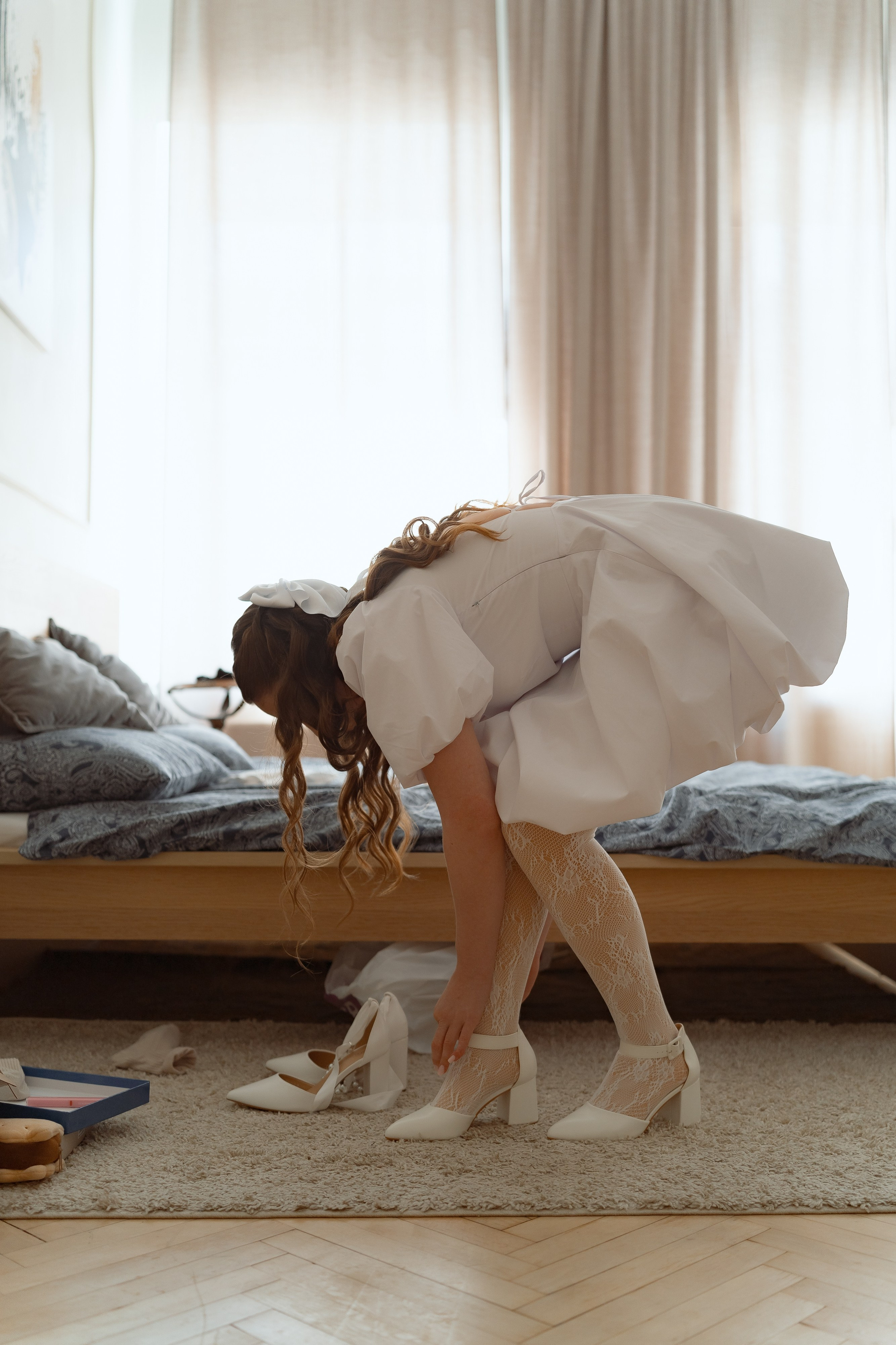 Невеста надевает свадебные туфли, лёгкий и естественный кадр дома