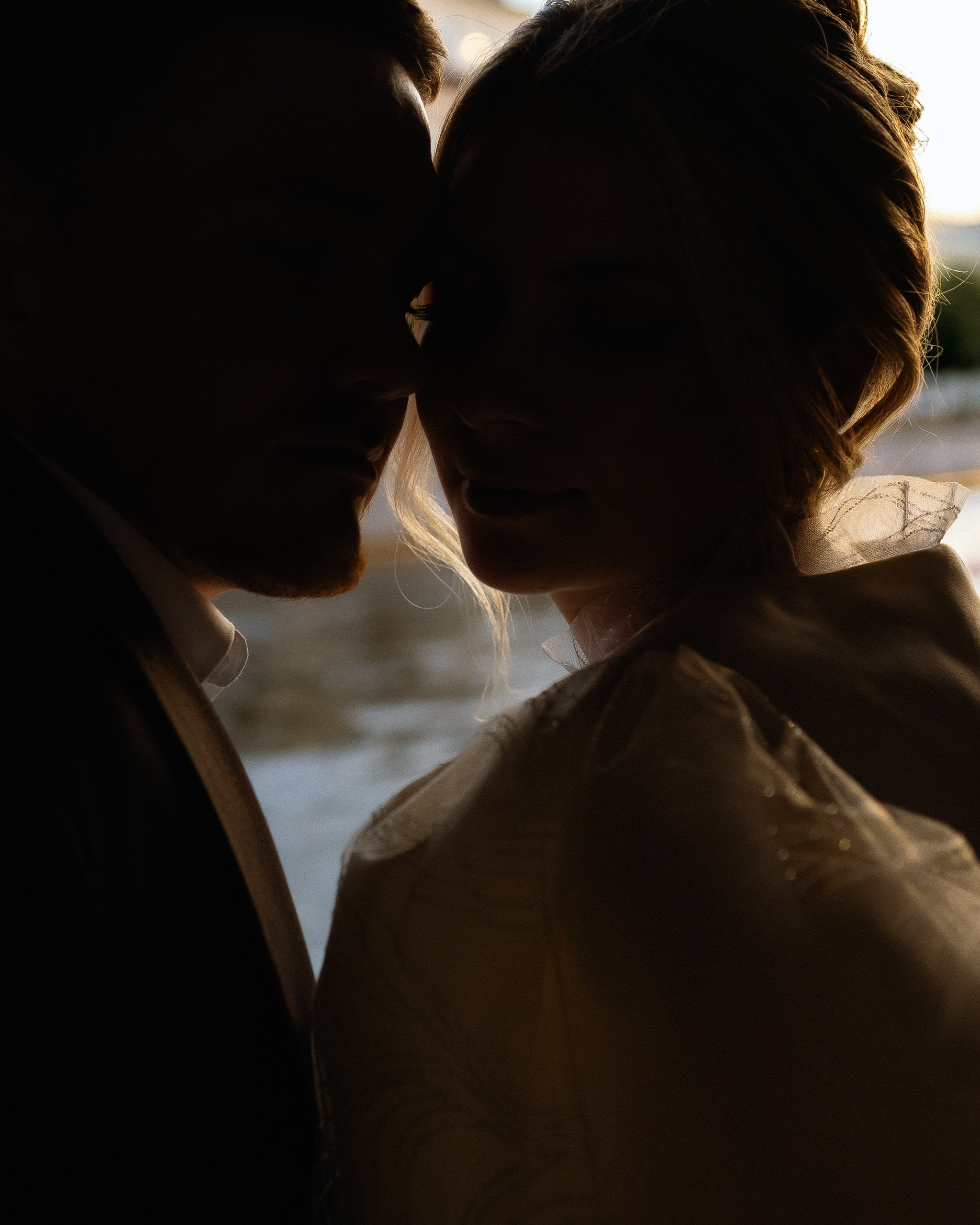 Силуэт пары на закате — интимный момент во время свадебной прогулки по реке