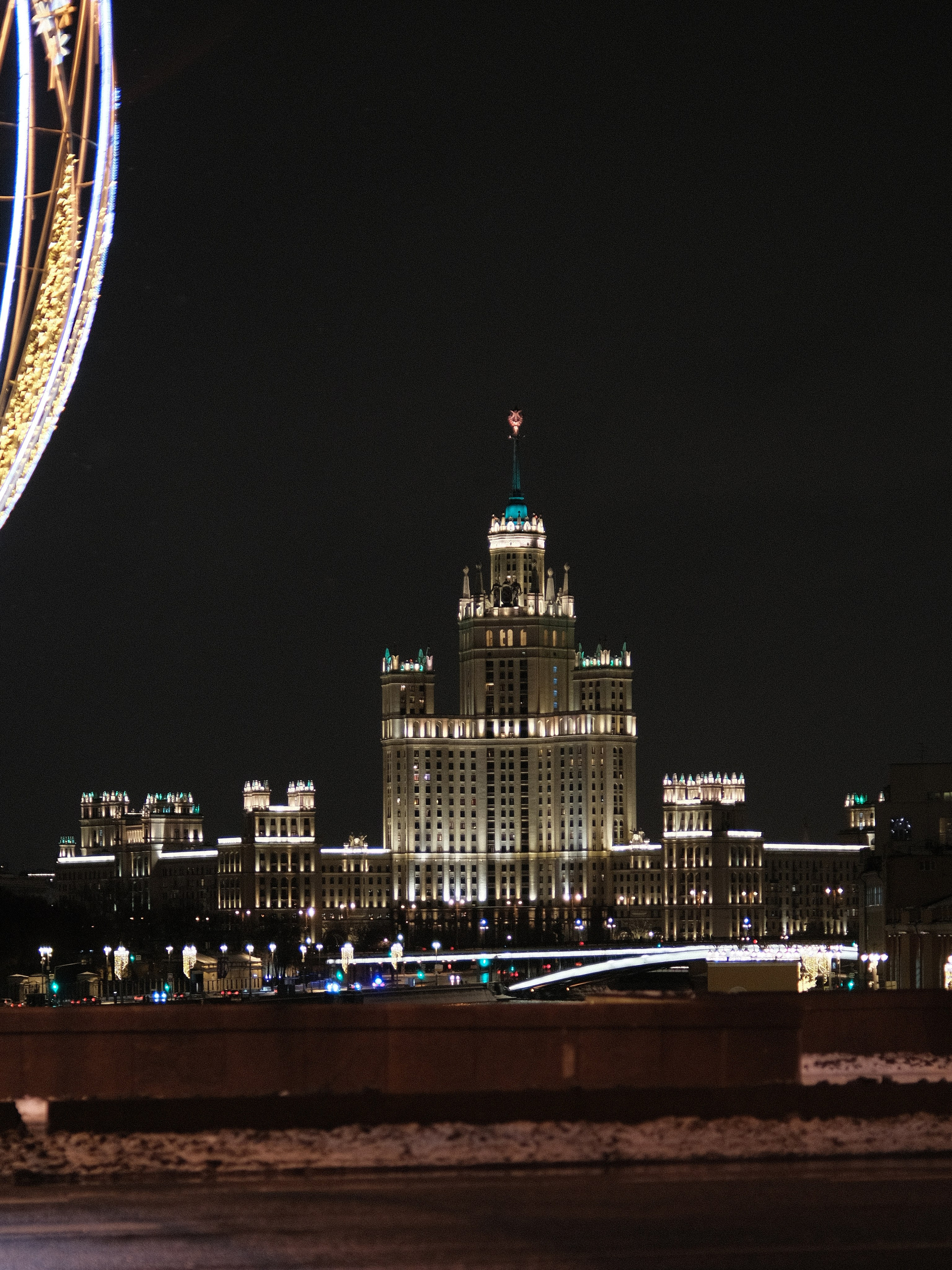 Зимняя Москва 2025, сталинская высотка на Котельнической набережной в вечерней подсветке, ночной вид с моста